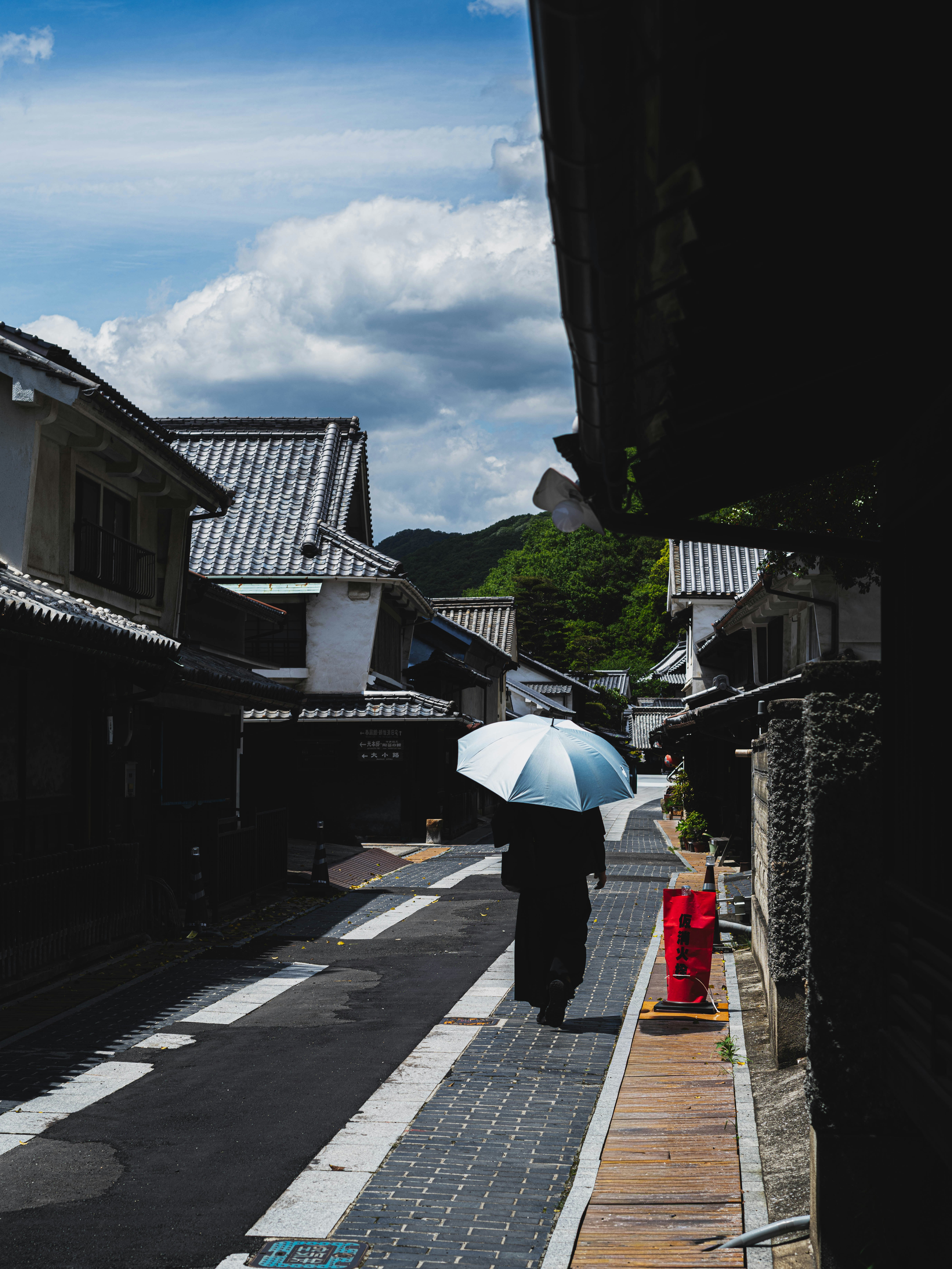 竹原の古い町並みで日傘をさす人のシルエット