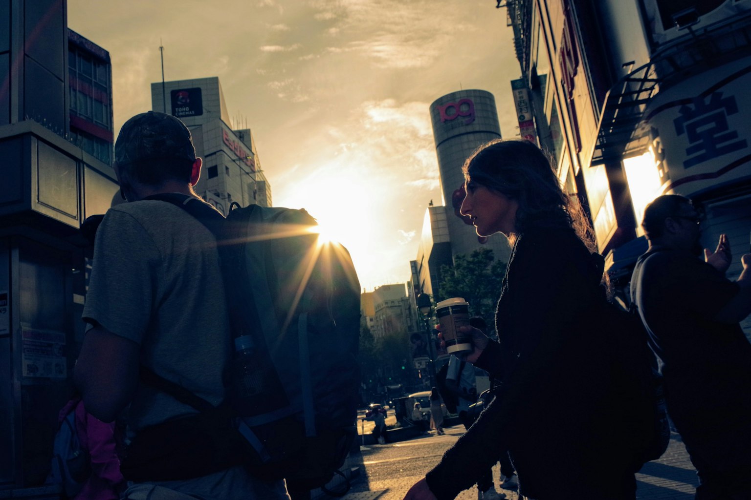 Silhouetten von Fußgängern vor einem Sonnenuntergang in einer urbanen Umgebung