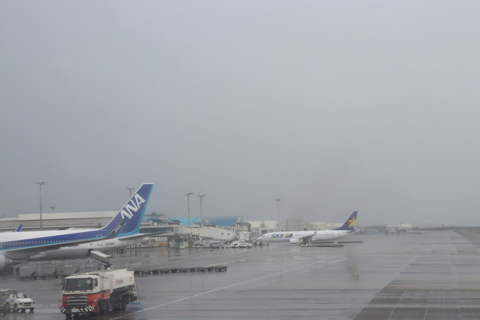 Avions garés sur la piste d'un aéroport par temps de pluie