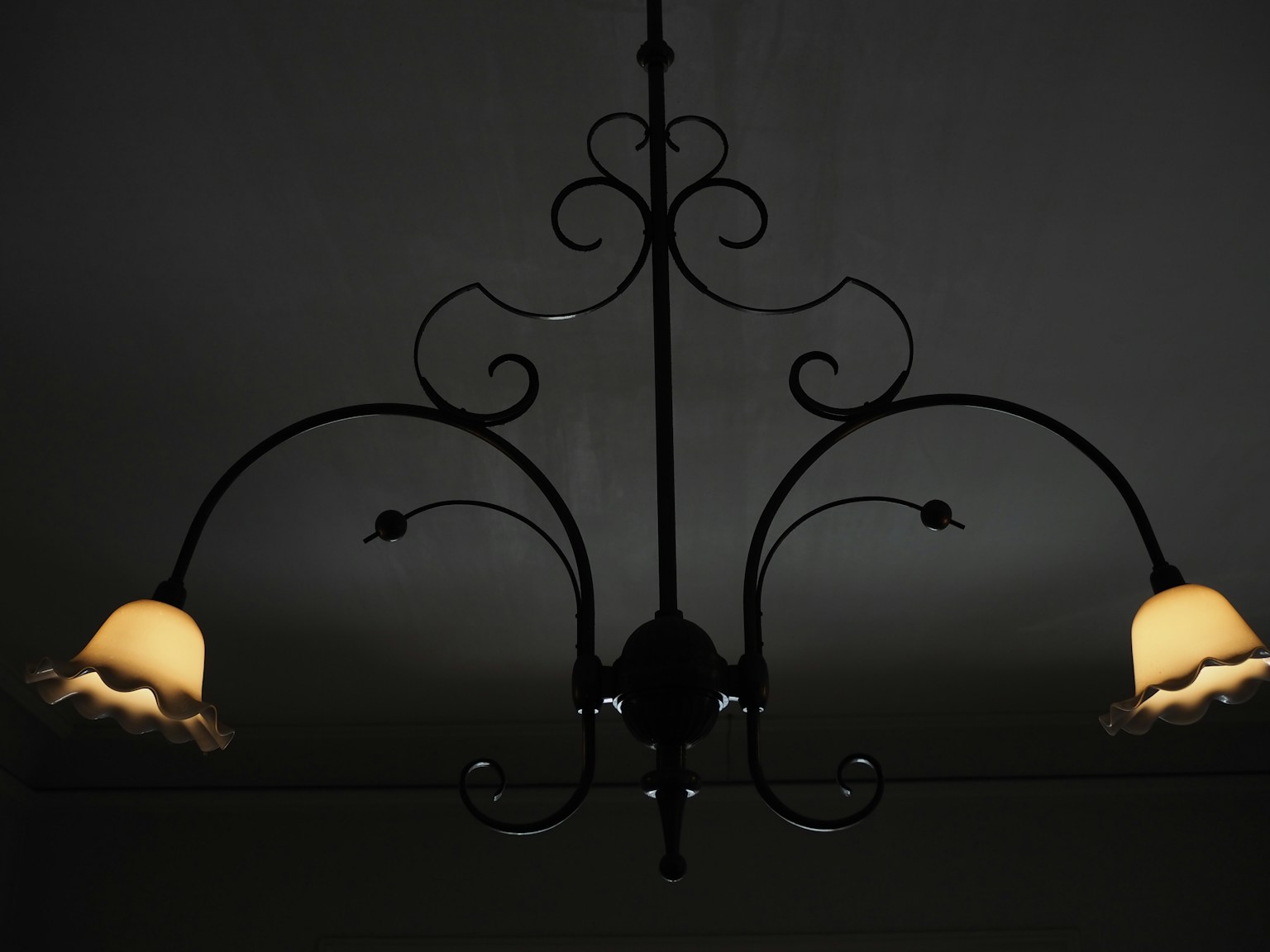 Black iron chandelier with cream-colored shades