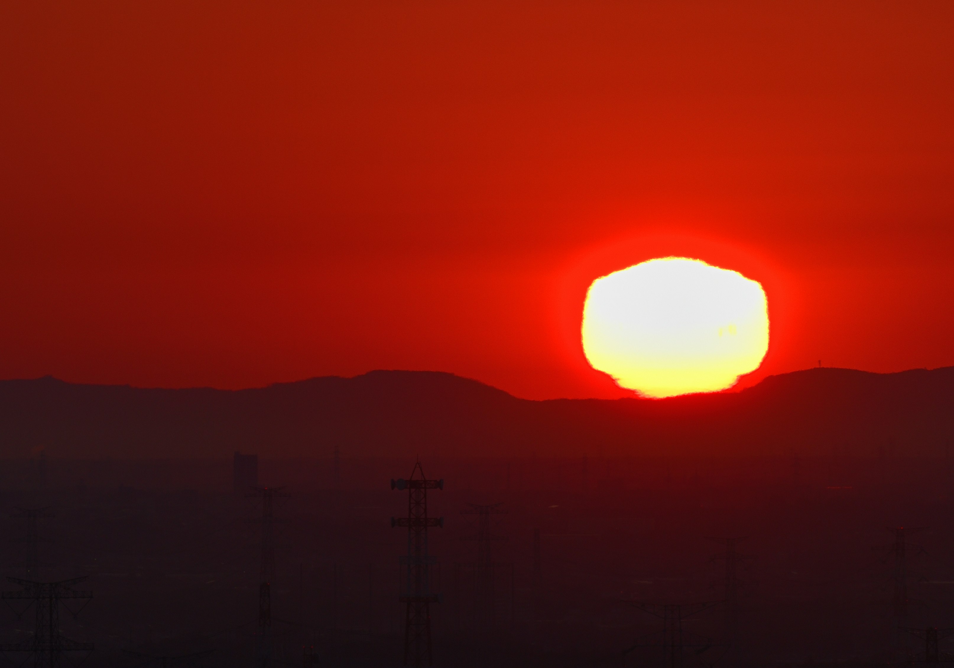 夕焼けの太陽が雲のない空に沈むシルエットの風景