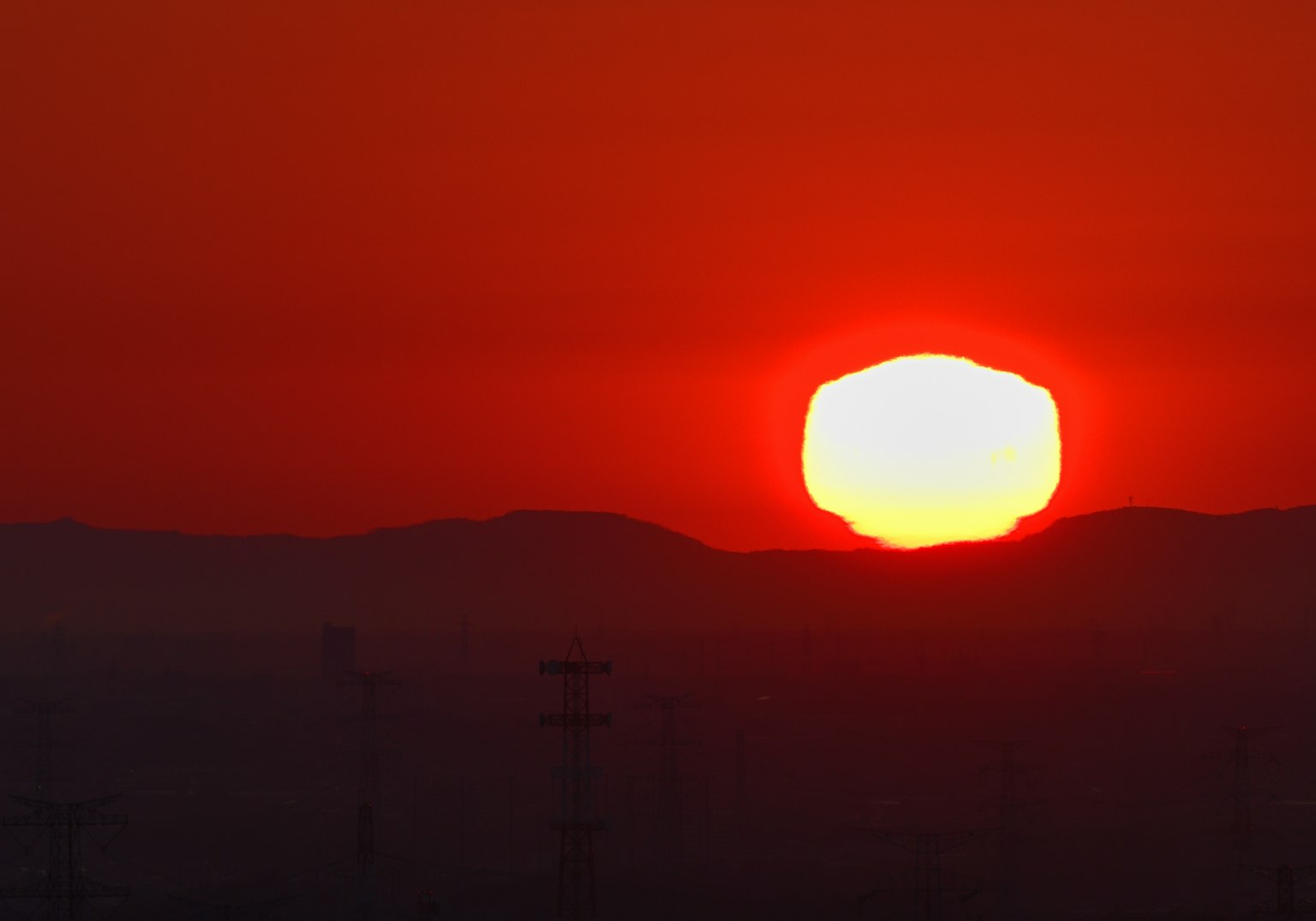 Coucher de soleil orange sur des montagnes silhouettées avec un ciel vibrant