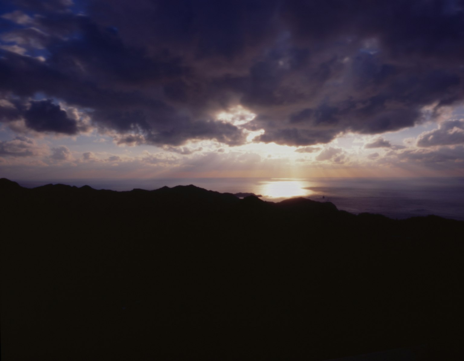 海上的日落与黑暗的山丘轮廓