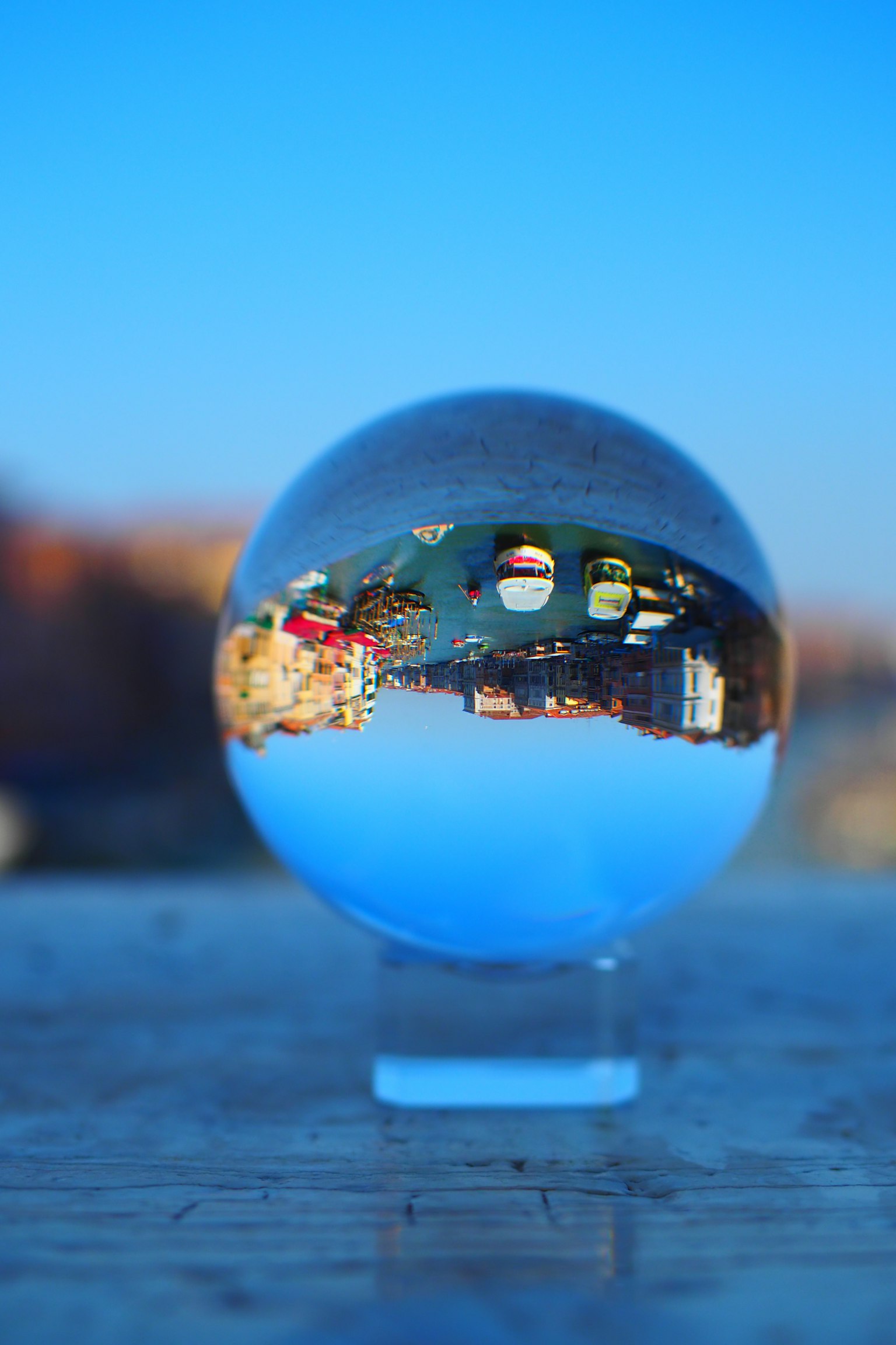 Palla di cristallo che riflette un paesaggio con cielo blu