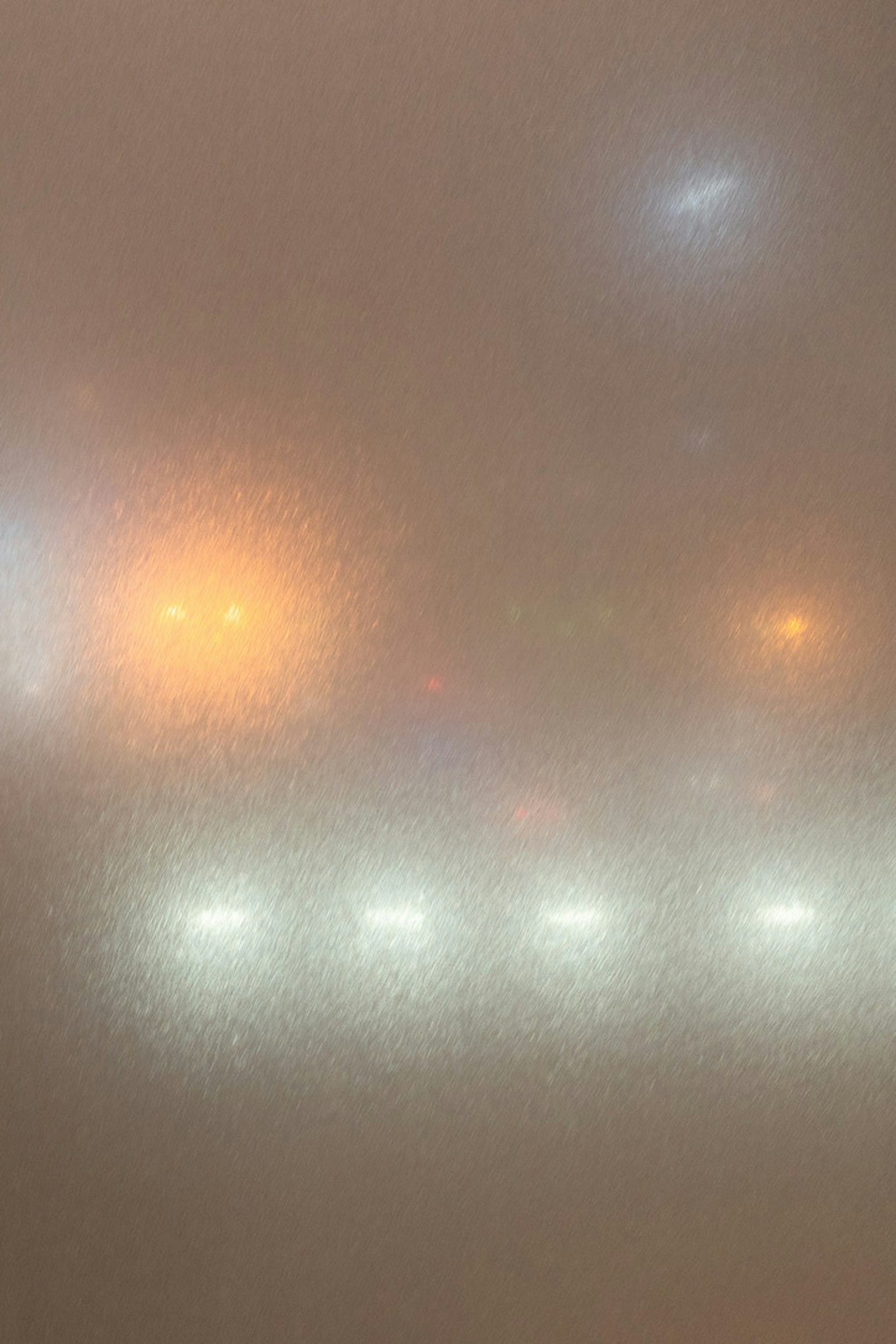 Luci sfocate di veicoli e lampioni nella nebbia