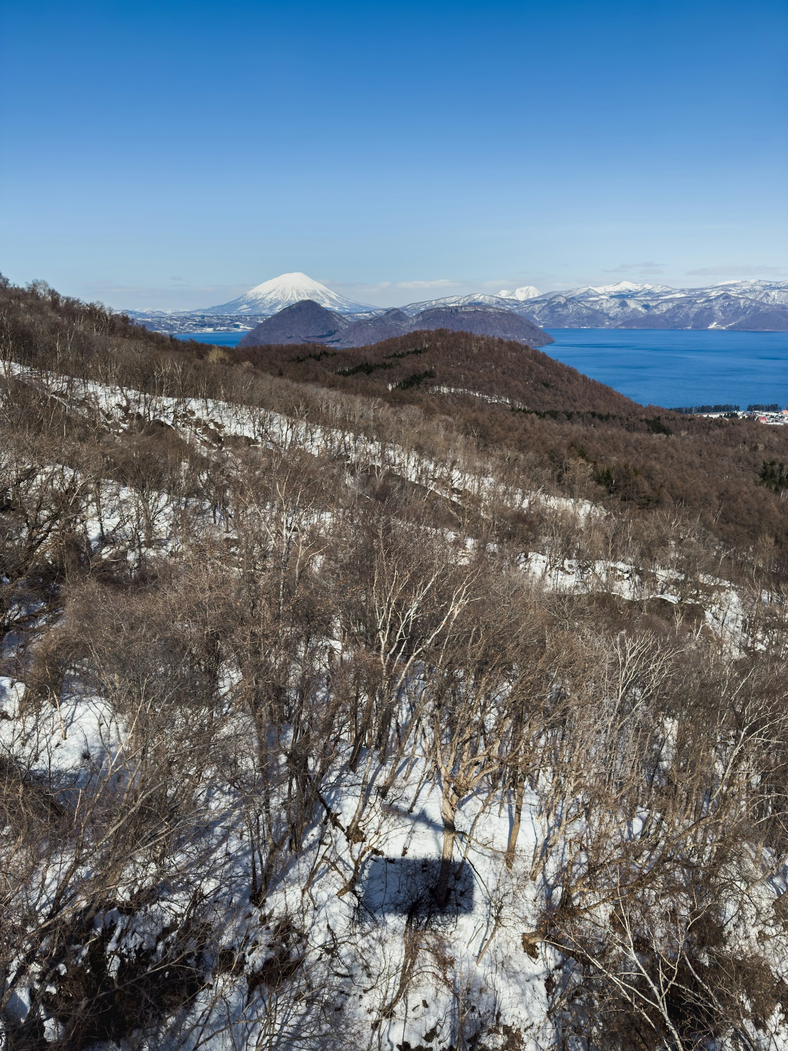 Snow-covered mountain landscape with distant view of Mount Fuji