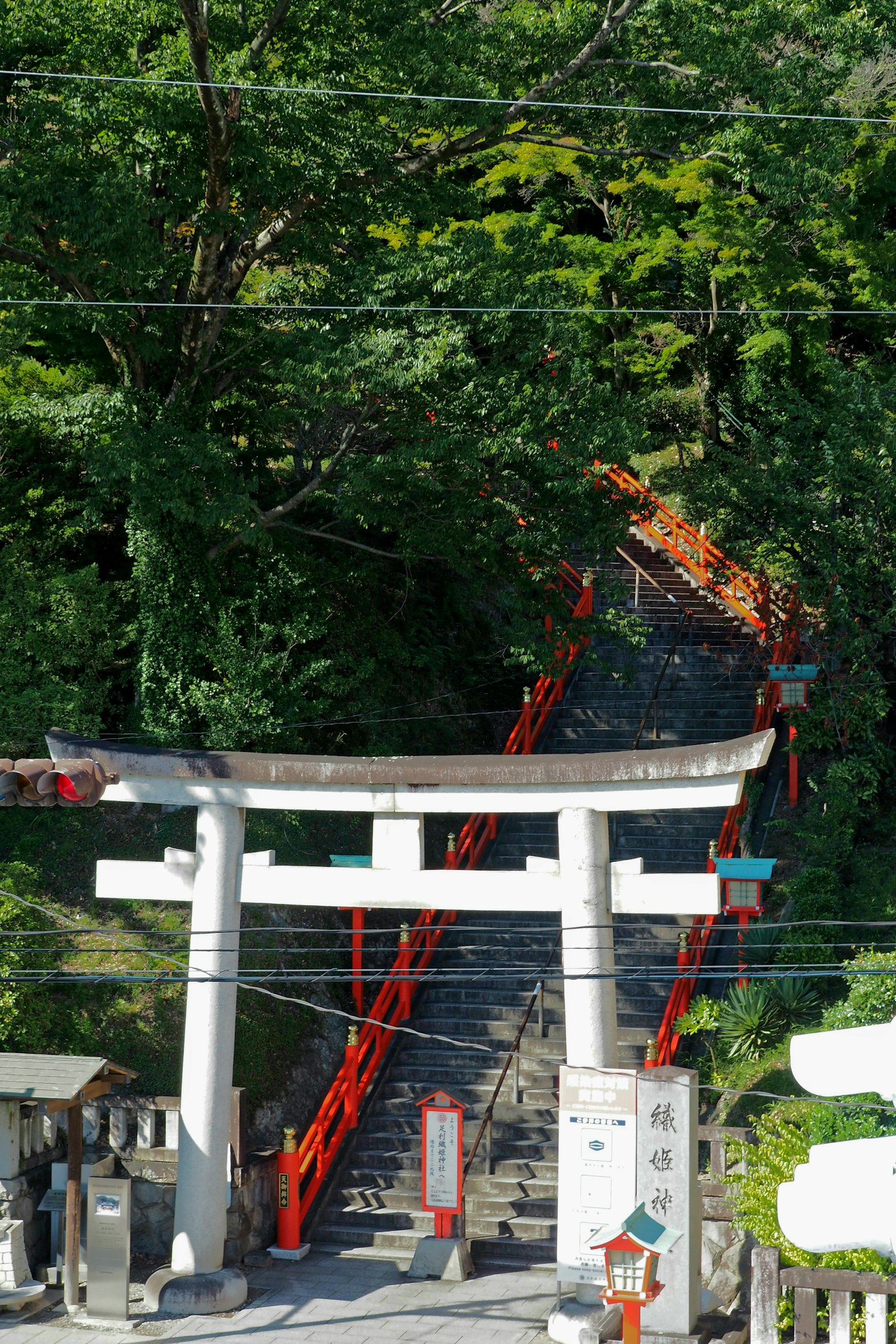 Eine malerische Ansicht eines Schreins mit einem Torii und roten Treppen mit Geländern