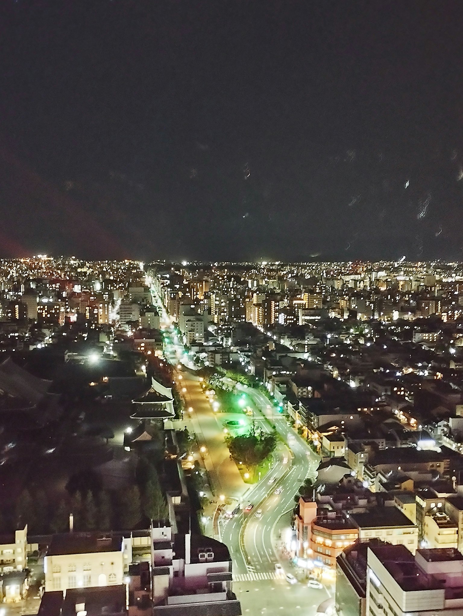 Vue nocturne de la ville avec des lampadaires brillants et des feux de circulation verts