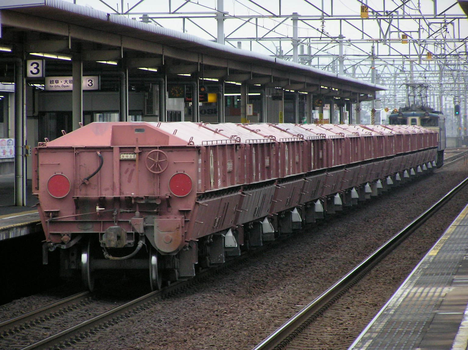 Train de marchandises rouge arrêté au quai
