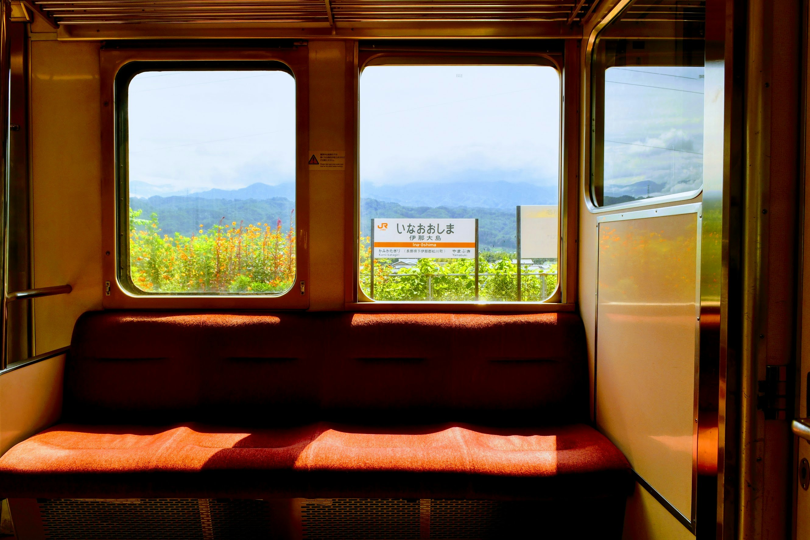 列車の車内から見える田園風景と山並み