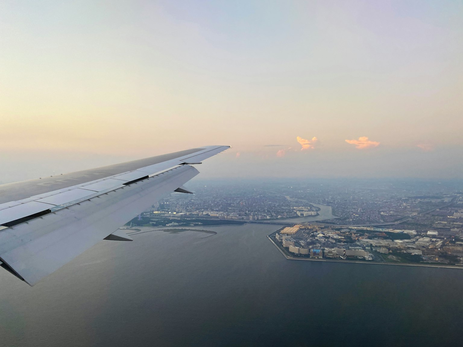 飞机翼上空的海洋和城市天际线的鸟瞰图