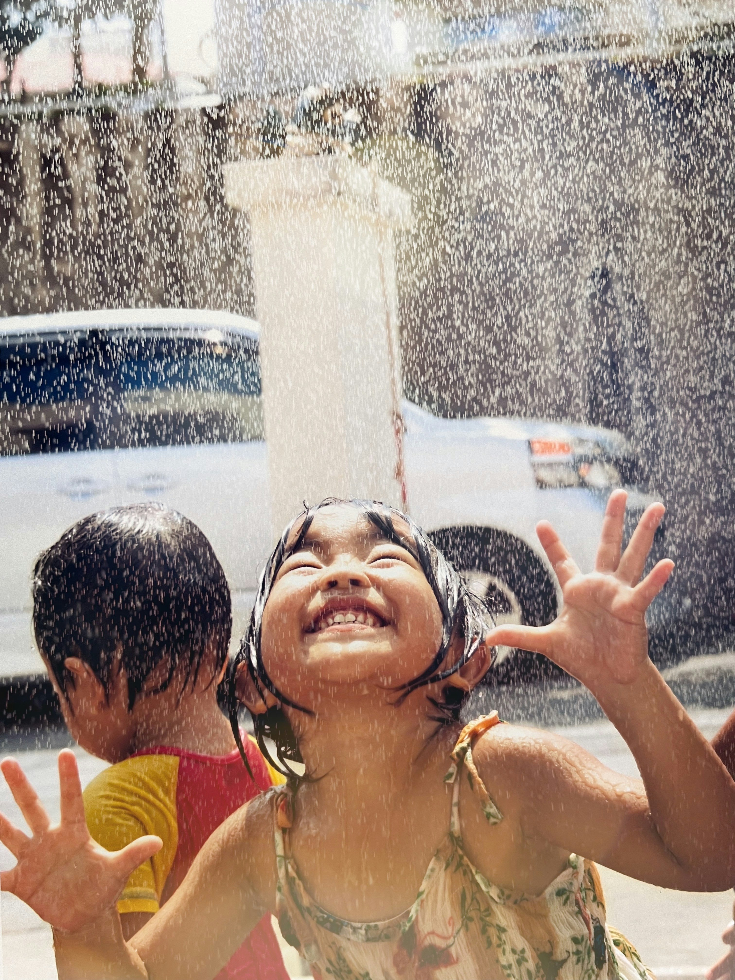 水しぶきを浴びて遊ぶ子供たちの夏の水遊び