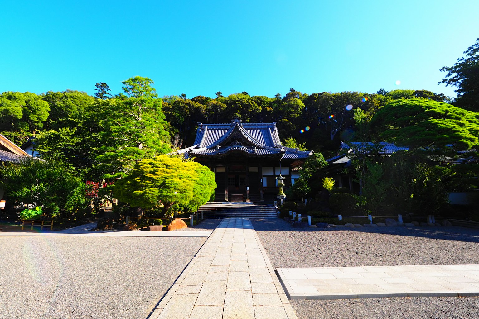 Traditional Japanese temple surrounded by lush greenery and gardens