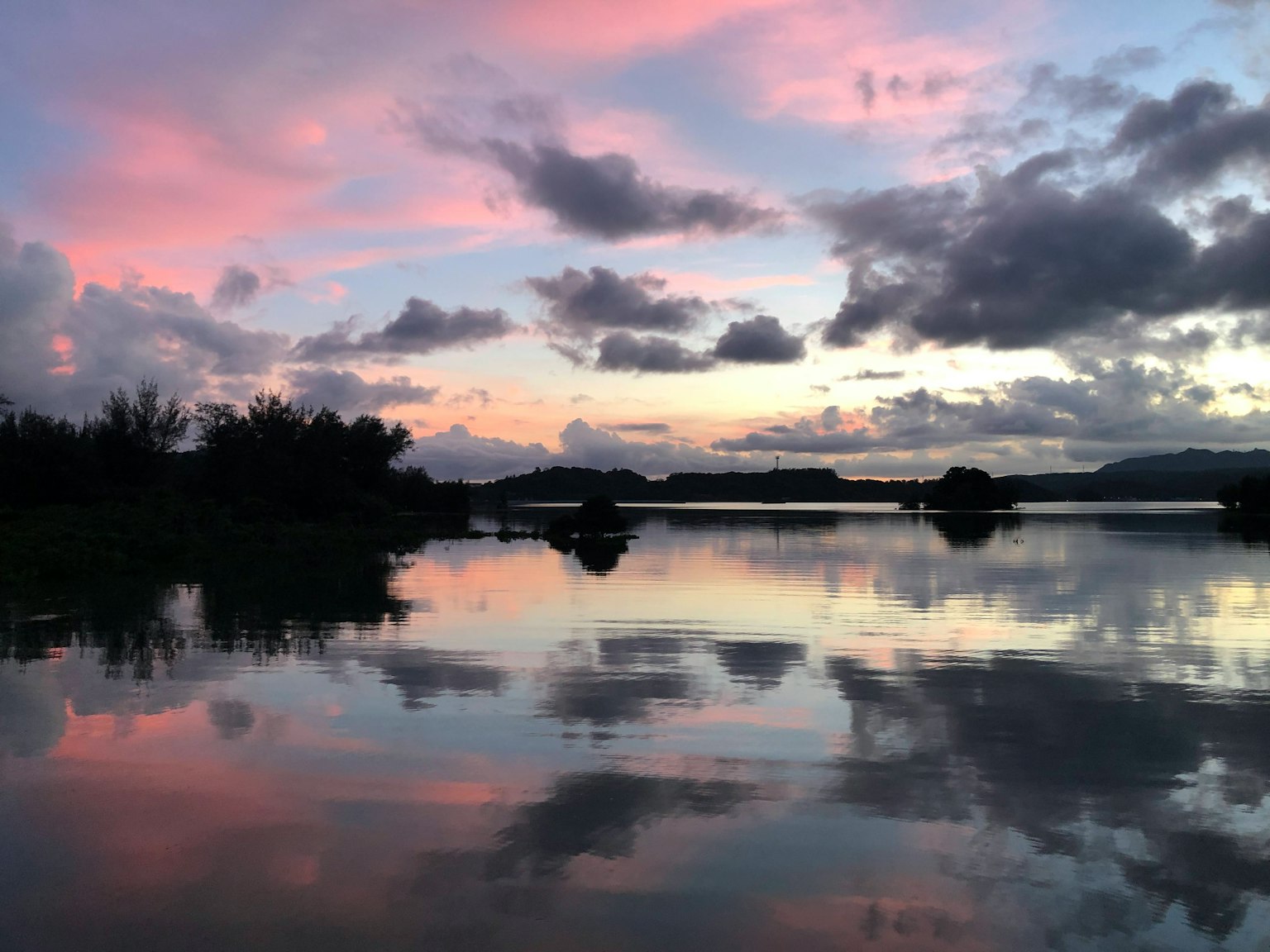 Paisaje de lago sereno reflejando un hermoso atardecer