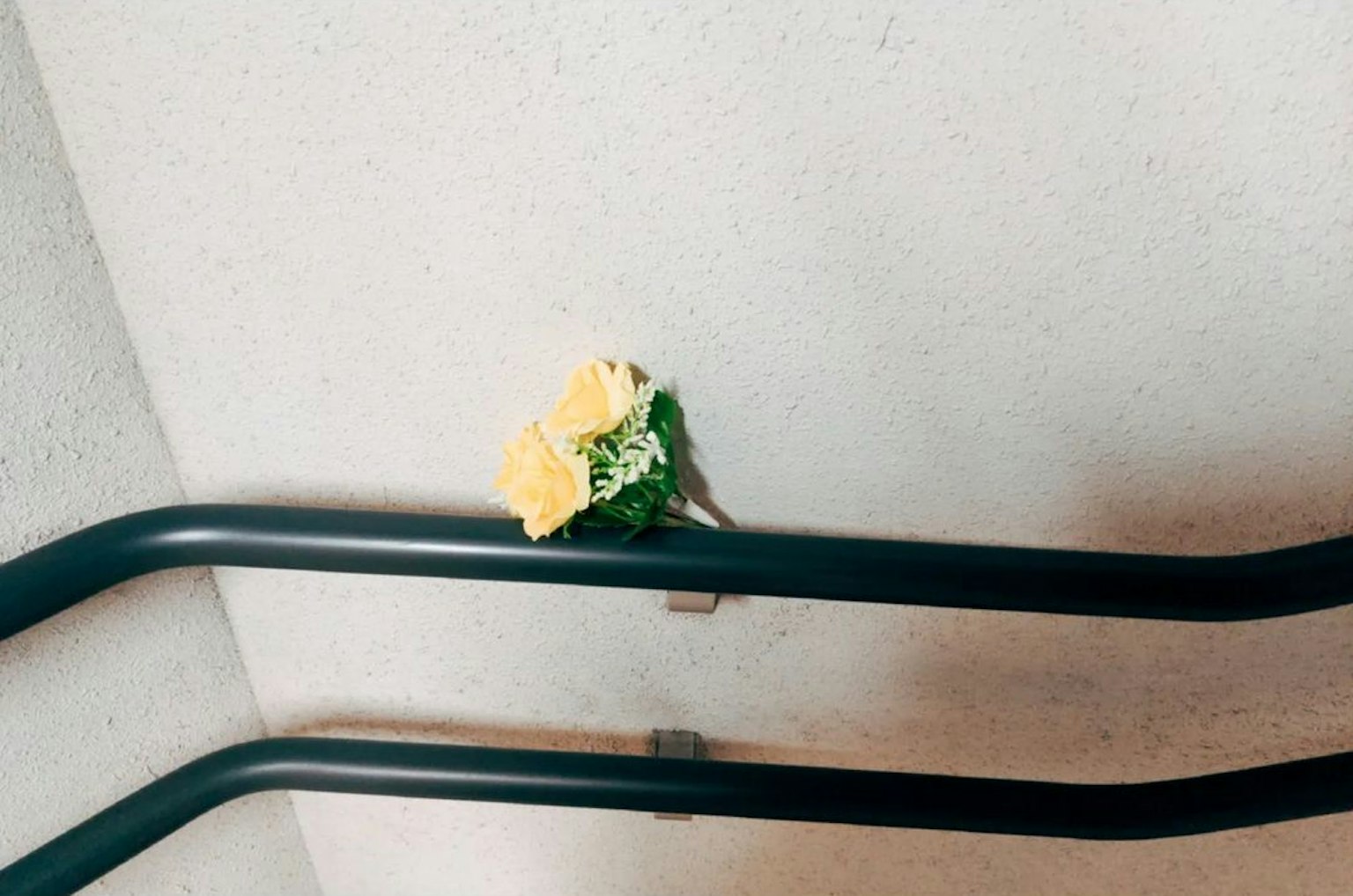 Corsage di fiori gialli e verdi posato su un corrimano di scale