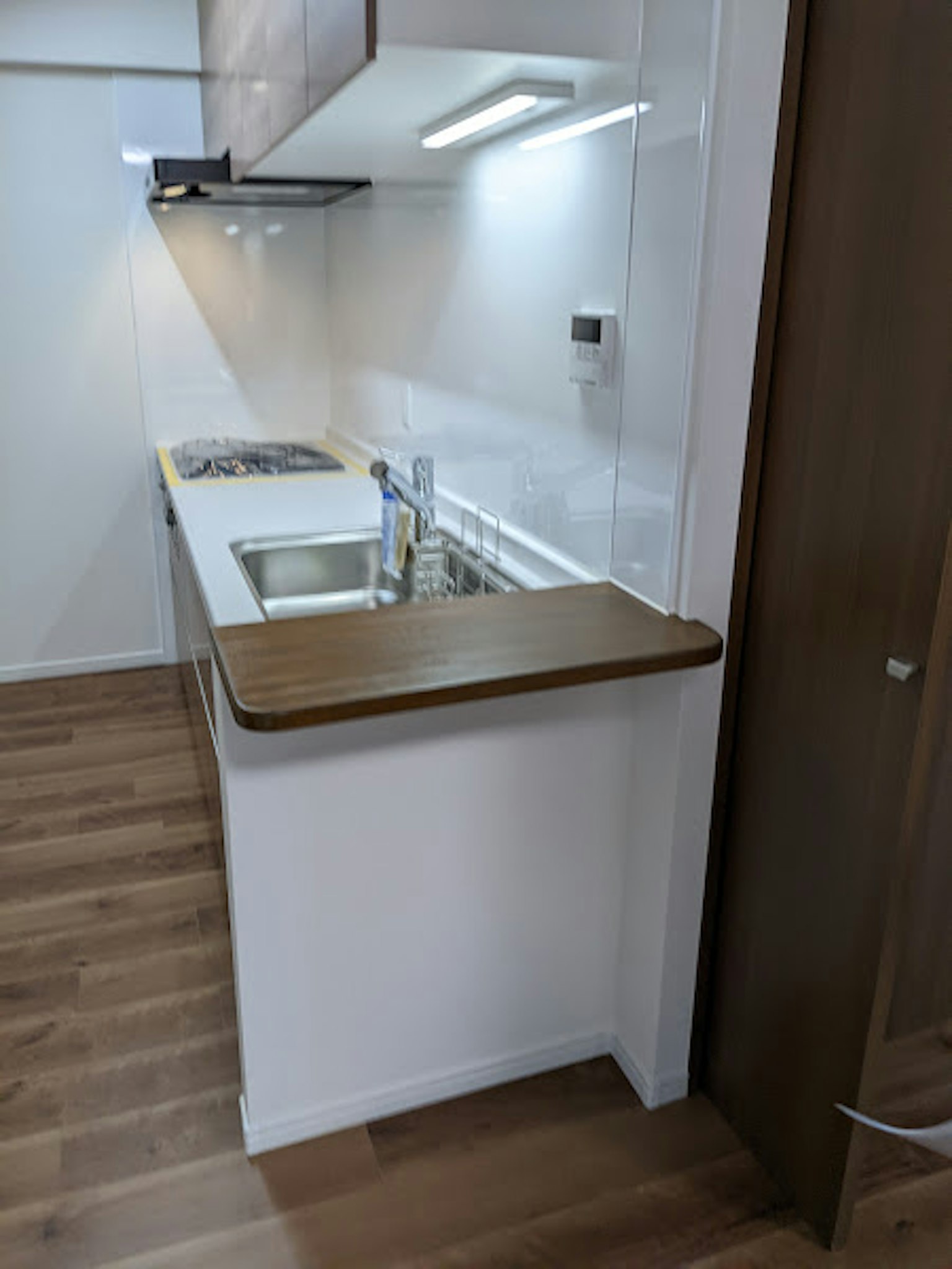 Modern kitchen design white cabinetry wooden countertop stainless steel sink