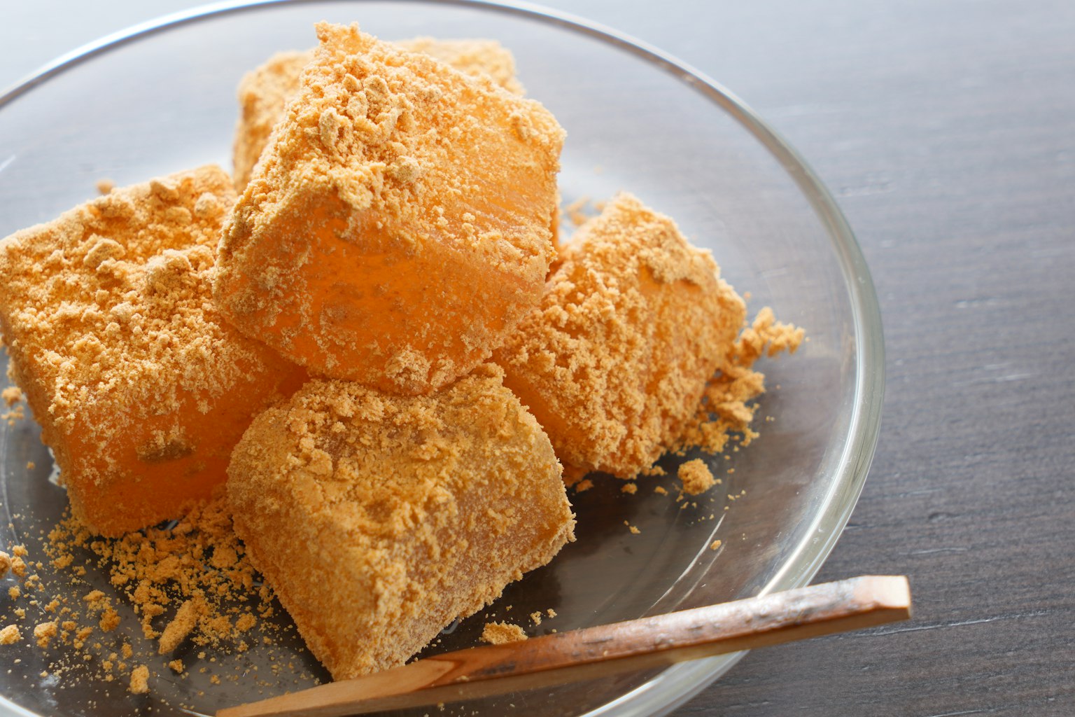 Una montagna di dolci giapponesi quadrati cosparsi di farina di soia su un piatto