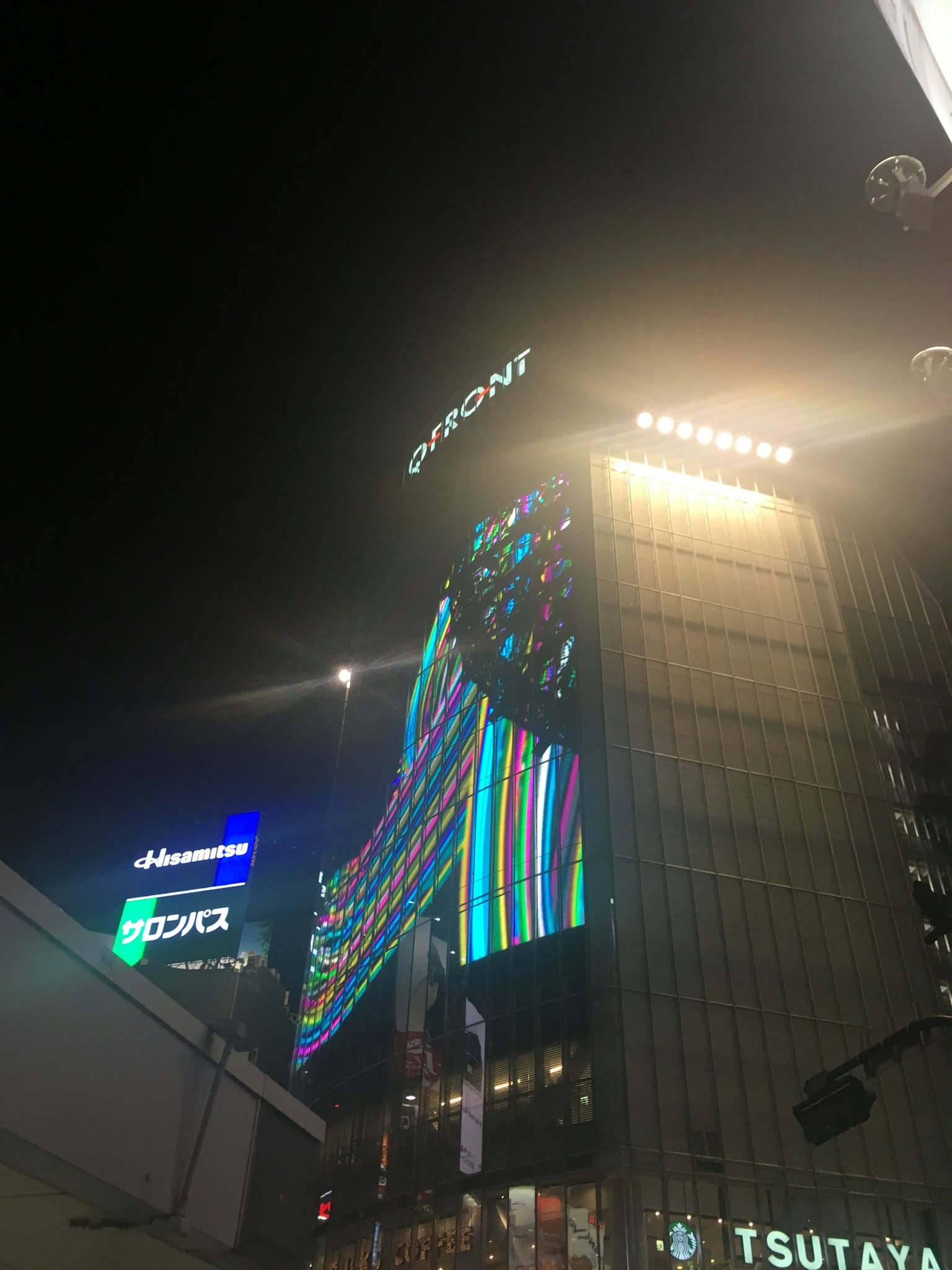Đèn neon nhiều màu sáng lên một tòa nhà vào ban đêm ở Shibuya