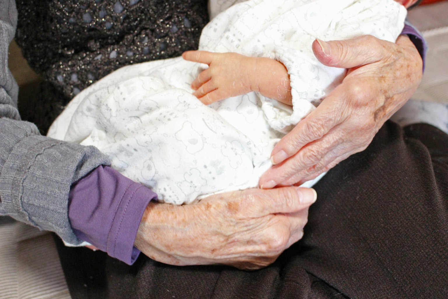 Una persona mayor sosteniendo una muñeca bebé