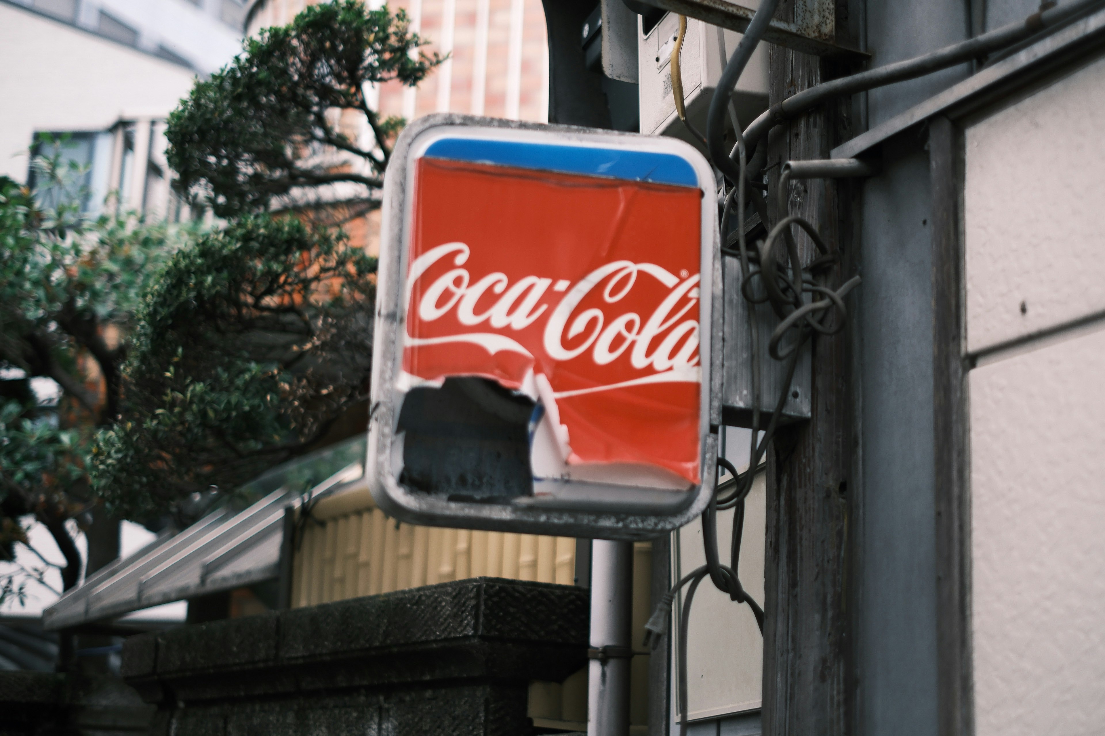cartel de Coca-Cola colgado en la pared de un callejón