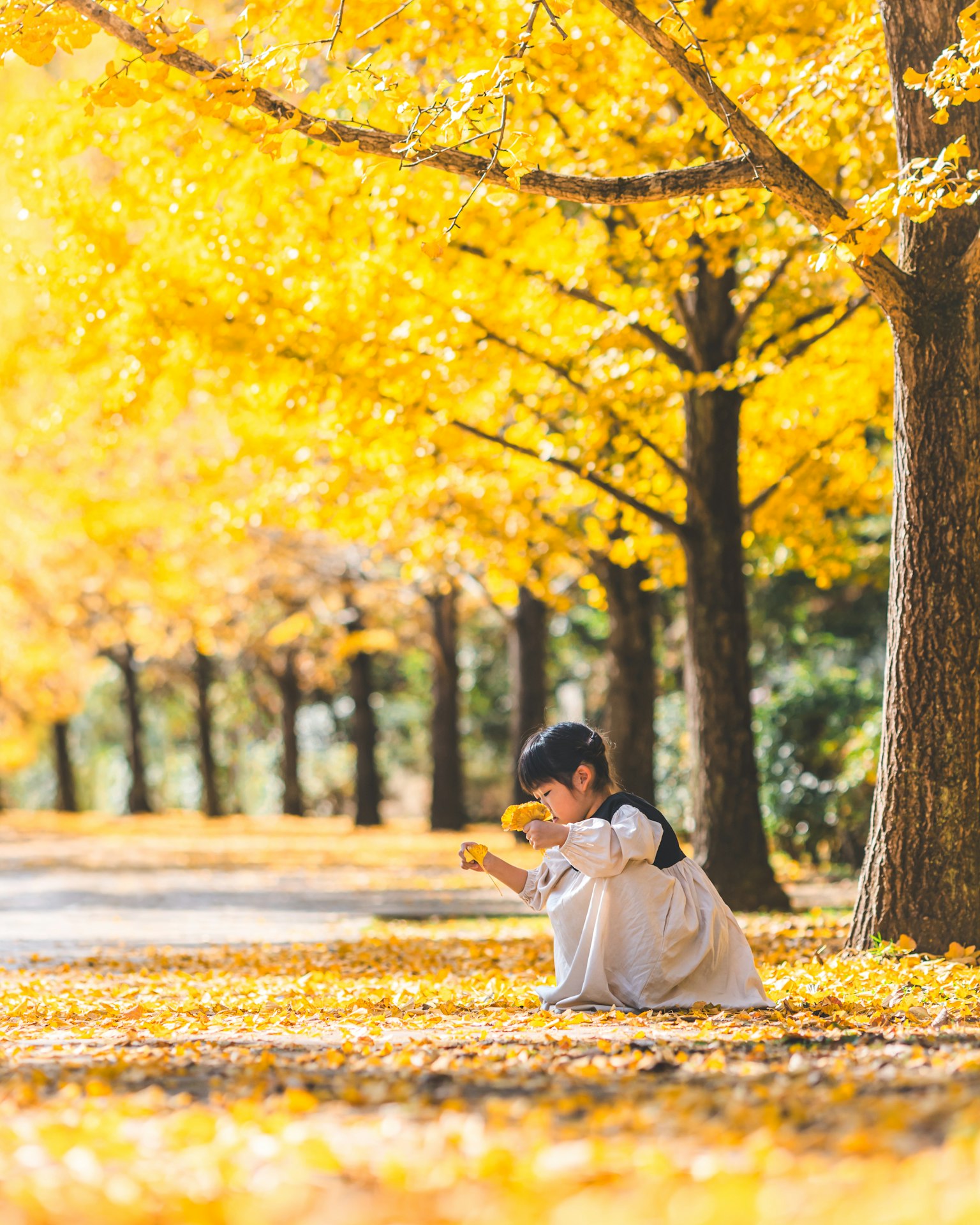 Enfant jouant parmi des feuilles d'automne jaunes vives