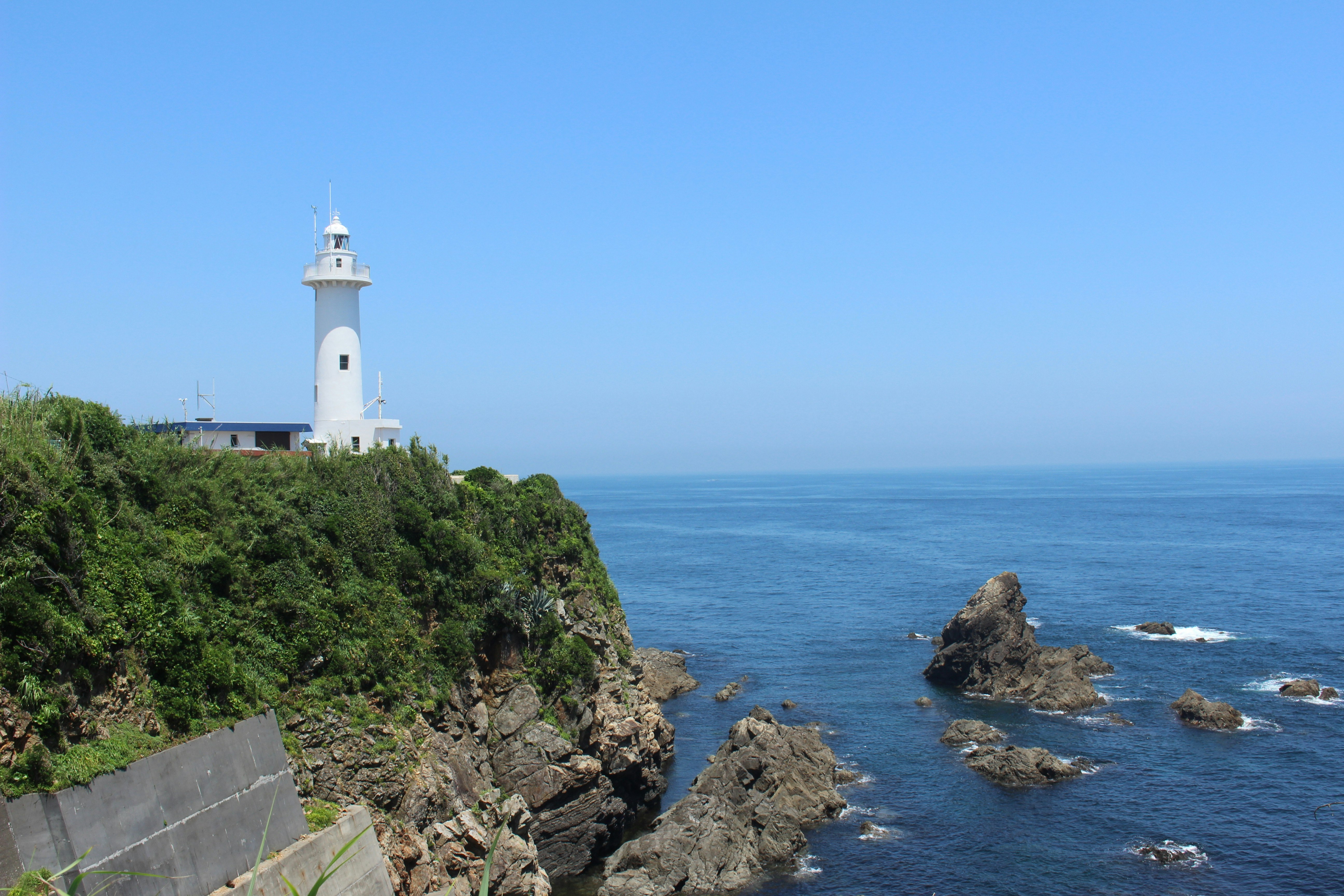 Vista de un faro costero y costa rocosa