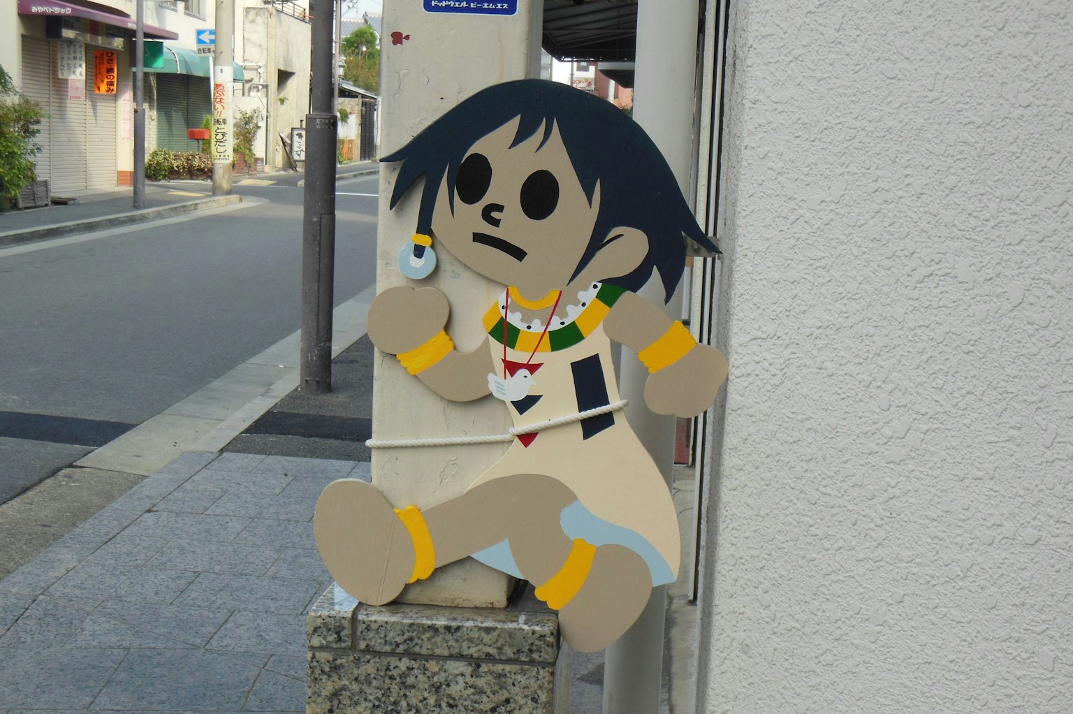 Personaje animado sentado en un poste de calle en una ciudad