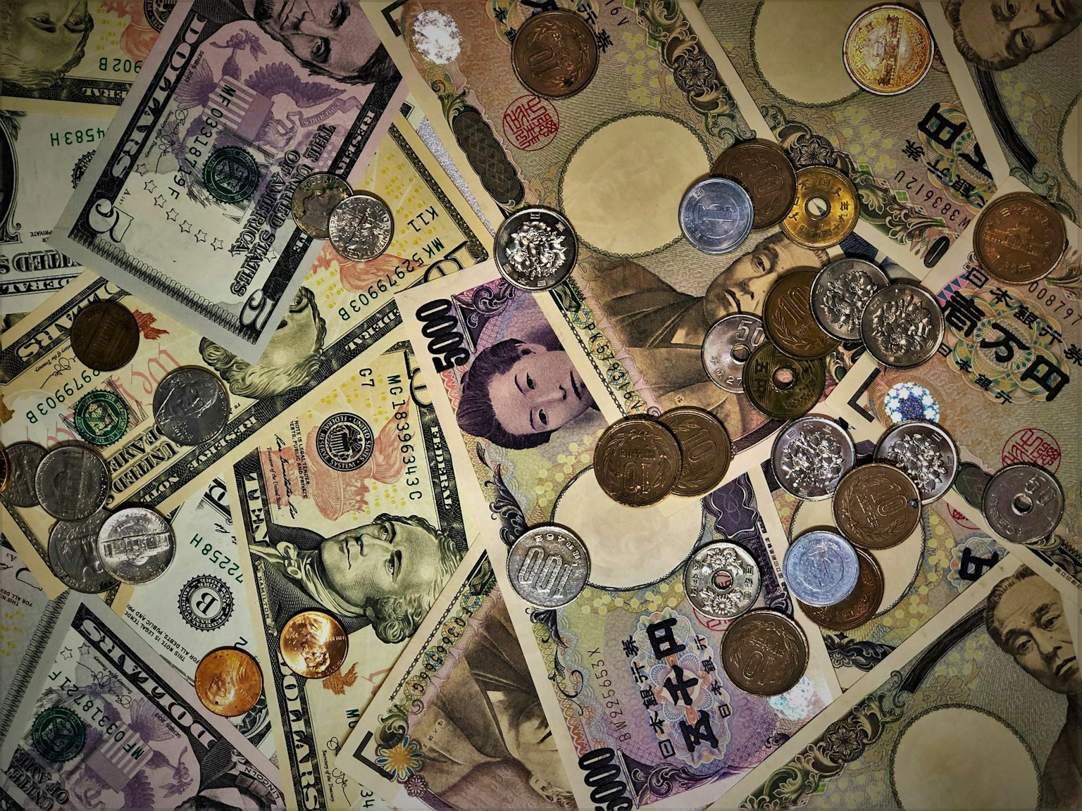 Un assortiment de billets et de pièces éparpillés sur une surface