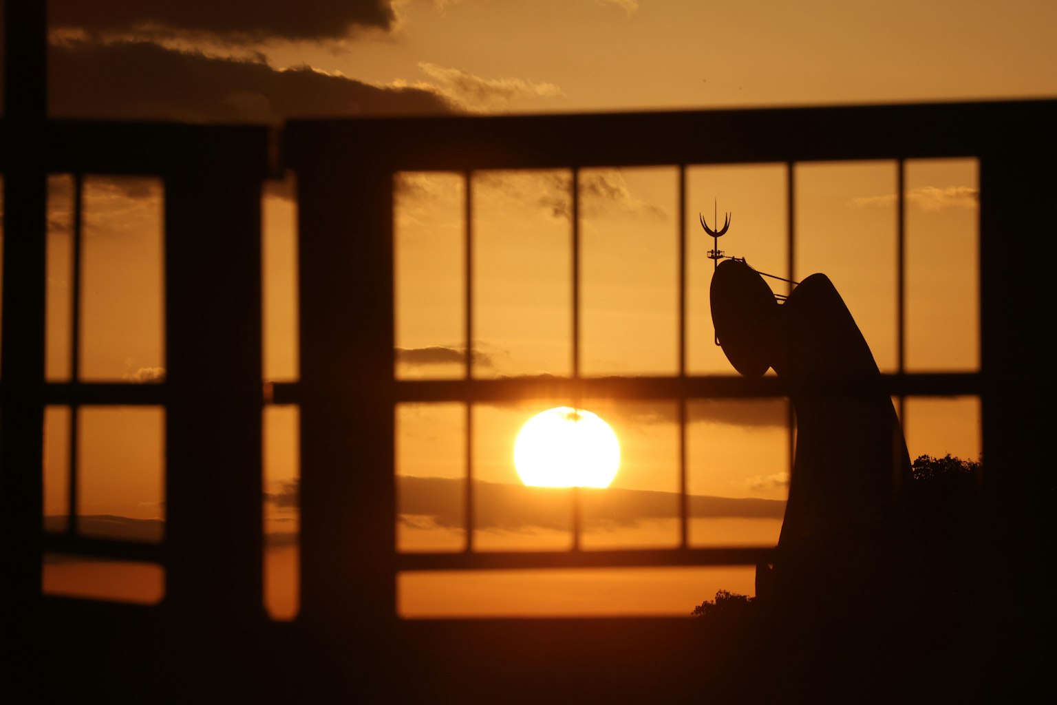 夕阳下窗户的剪影与天使雕像