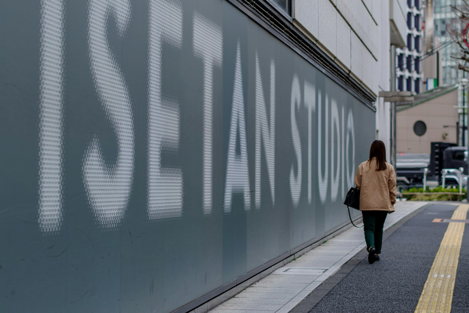 一位女性走过ISETAN STUDIO的墙