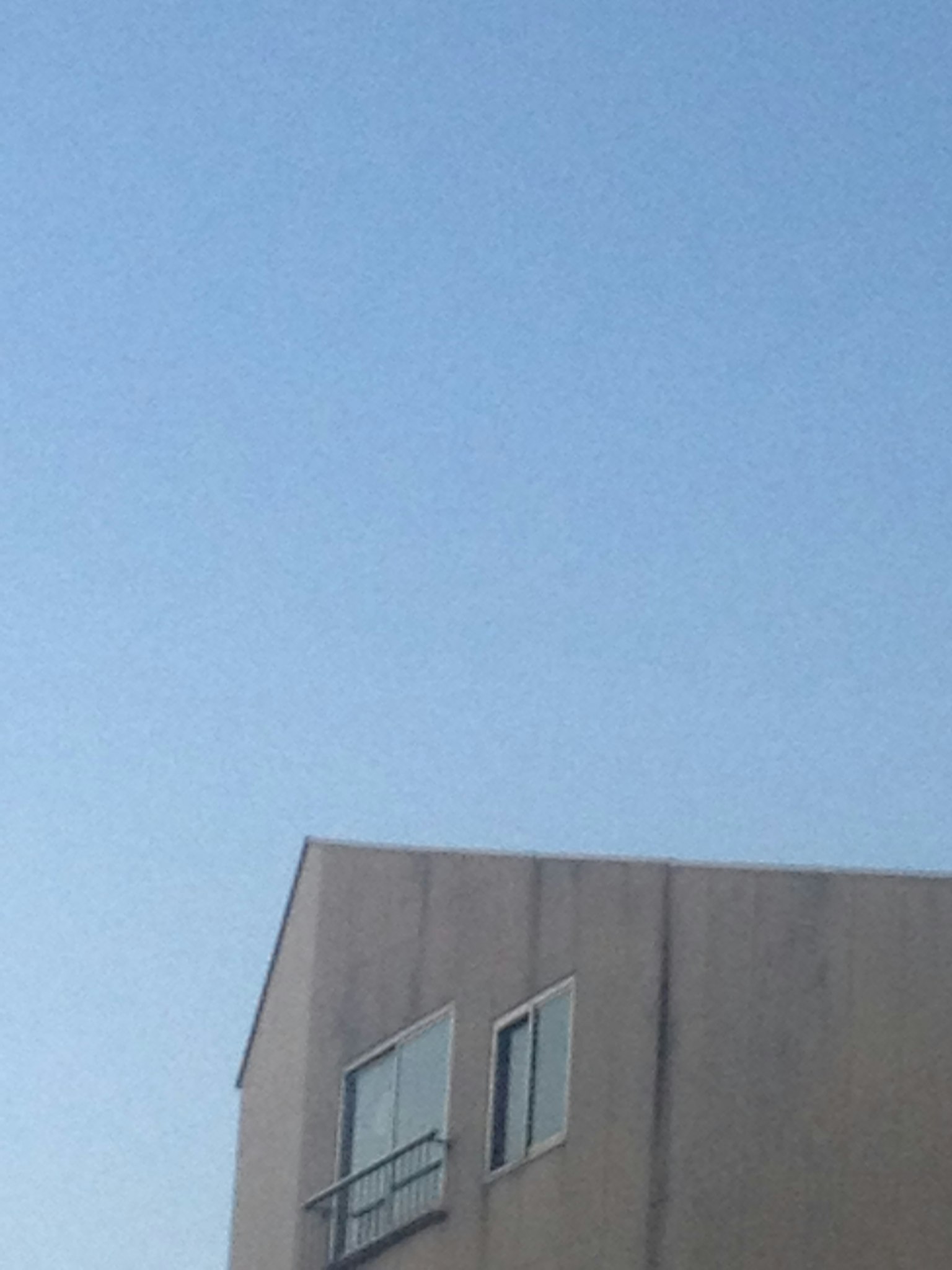 Teil eines Gebäudes mit Fenstern unter einem blauen Himmel