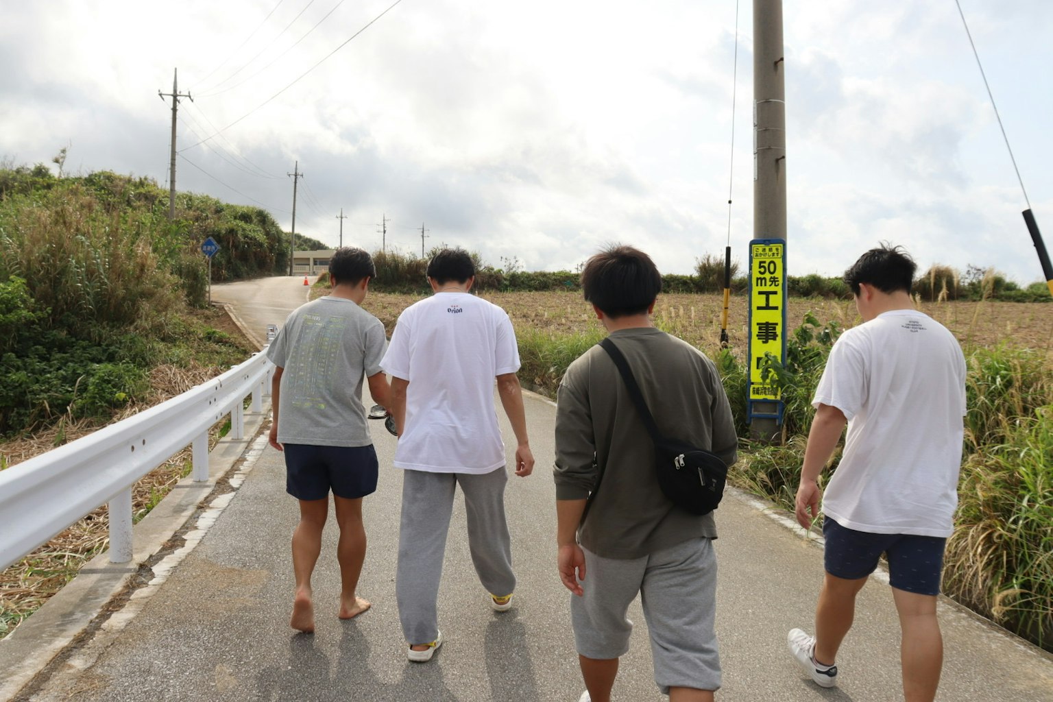 一群年輕男性在鄉村道路上行走