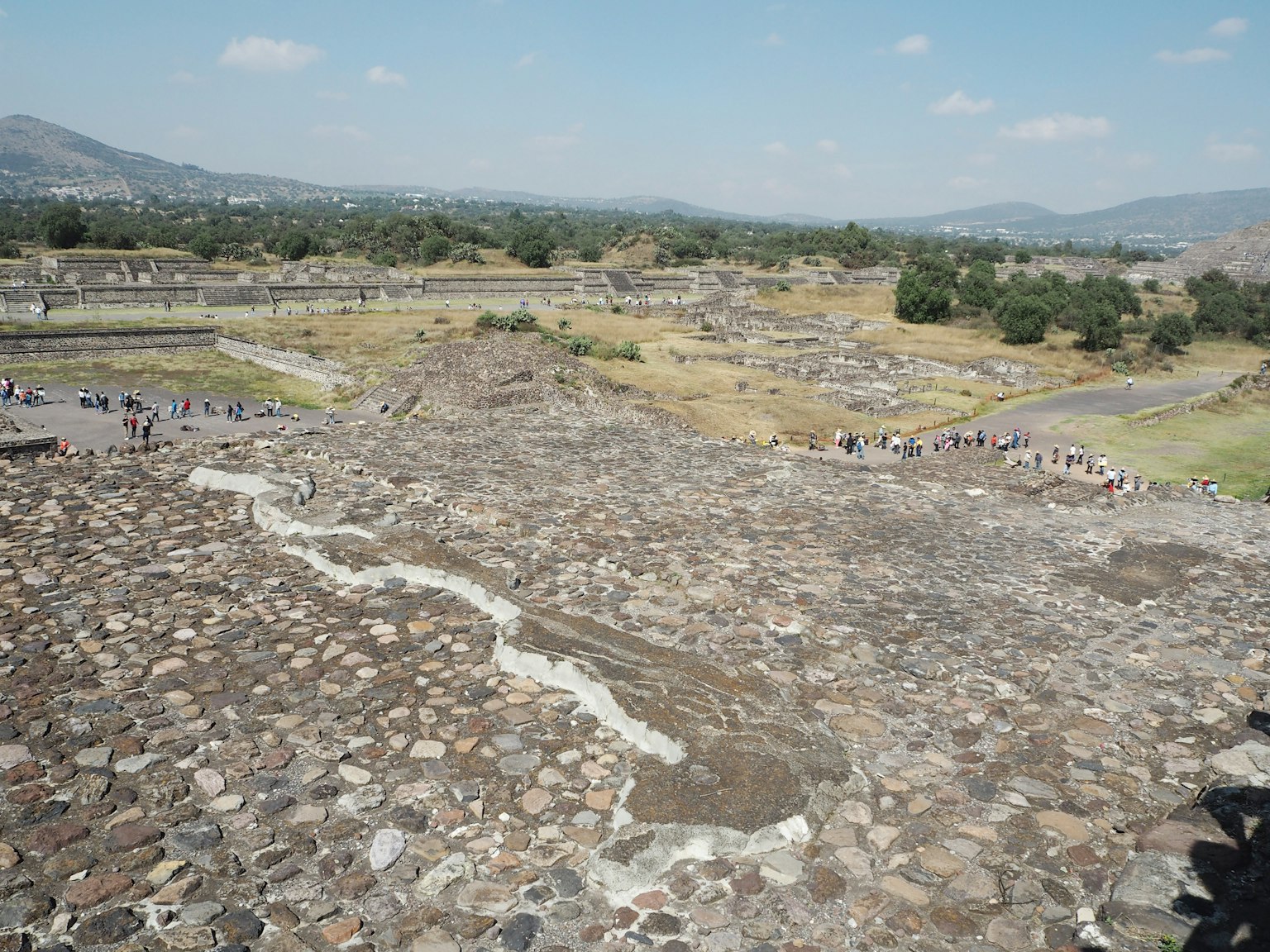 Panoramablick auf die weiten Ruinen von Teotihuacan mit Steinstrukturen und umliegendem Grün