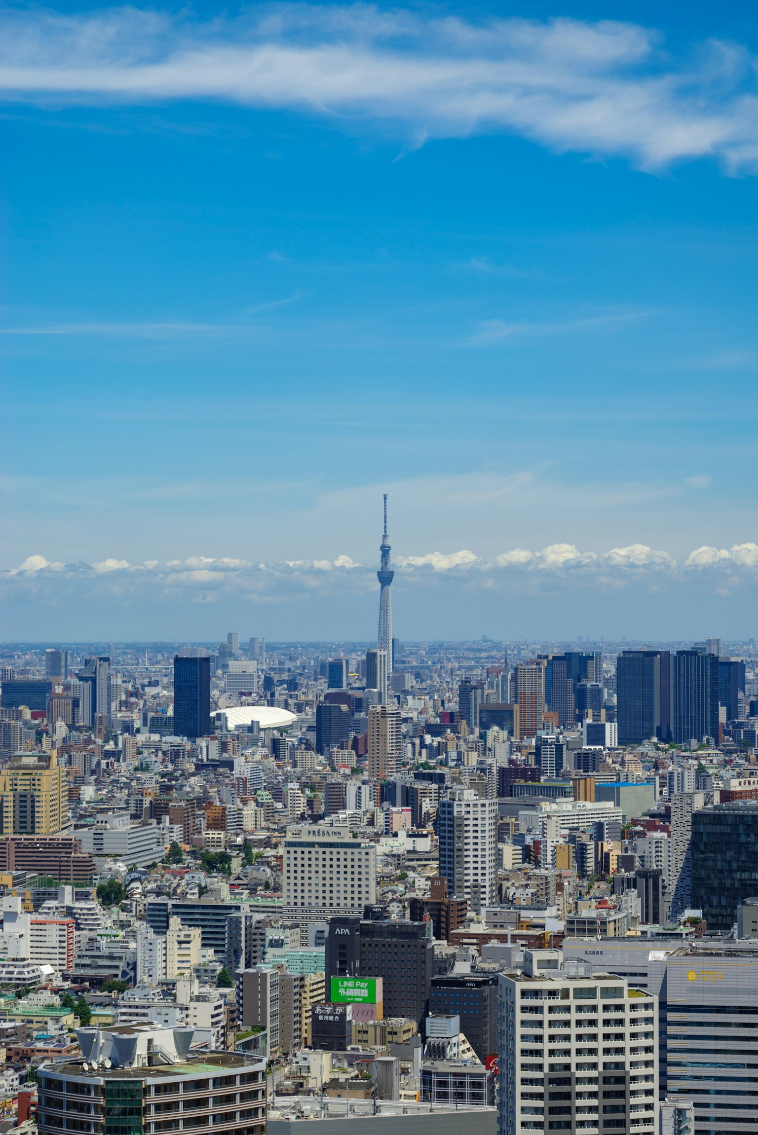 Tokyo cityscape featuring Tokyo Skytree under a clear blue sky with clouds