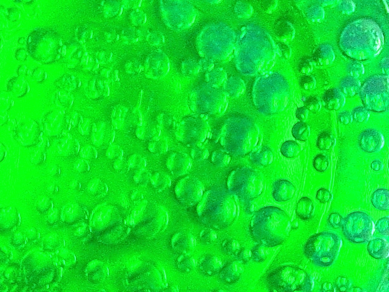 緑色の液体に浮かぶ気泡のマクロ