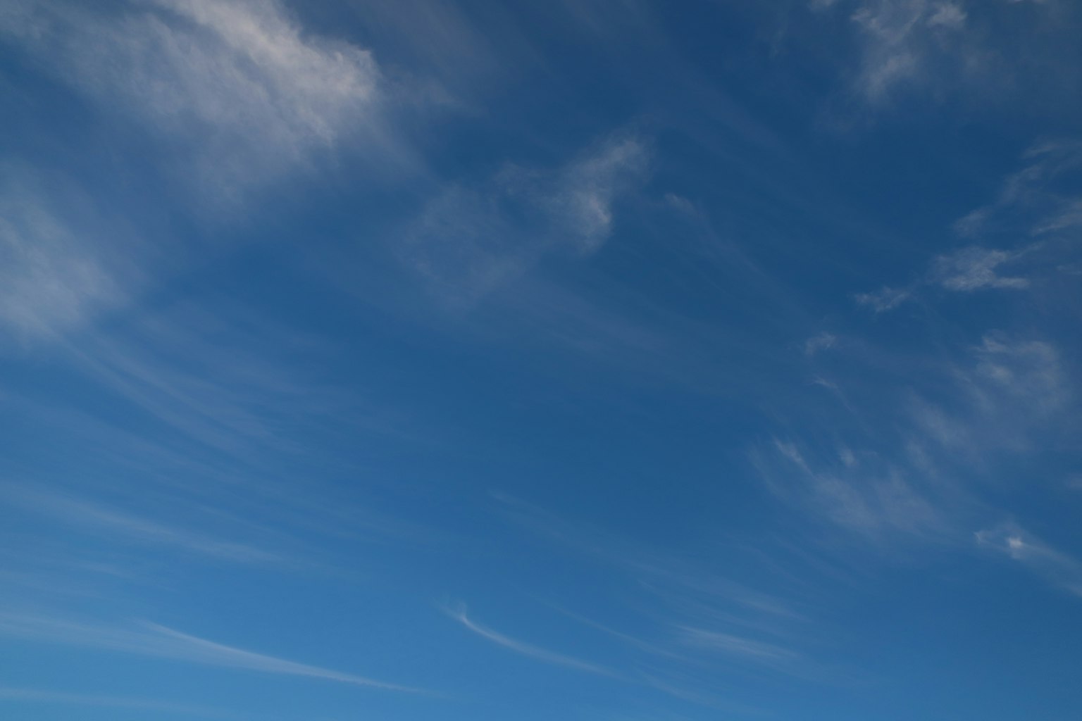 Blauer Himmel mit wispy weißen Wolken
