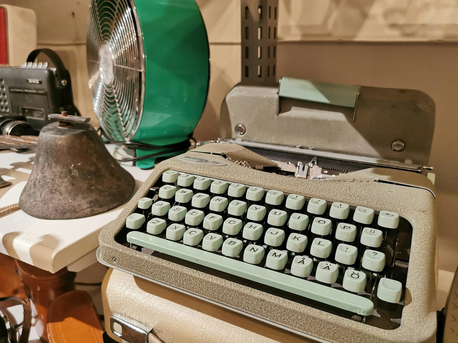 复古室内展示绿色打字机和古老的铃铛
