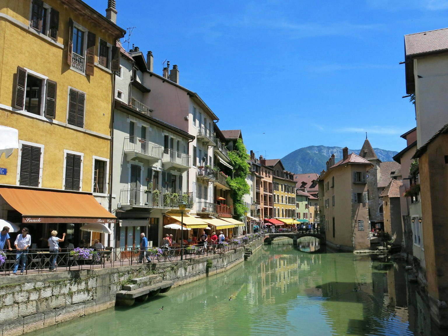 Canale affascinante con edifici colorati e caffè all'aperto
