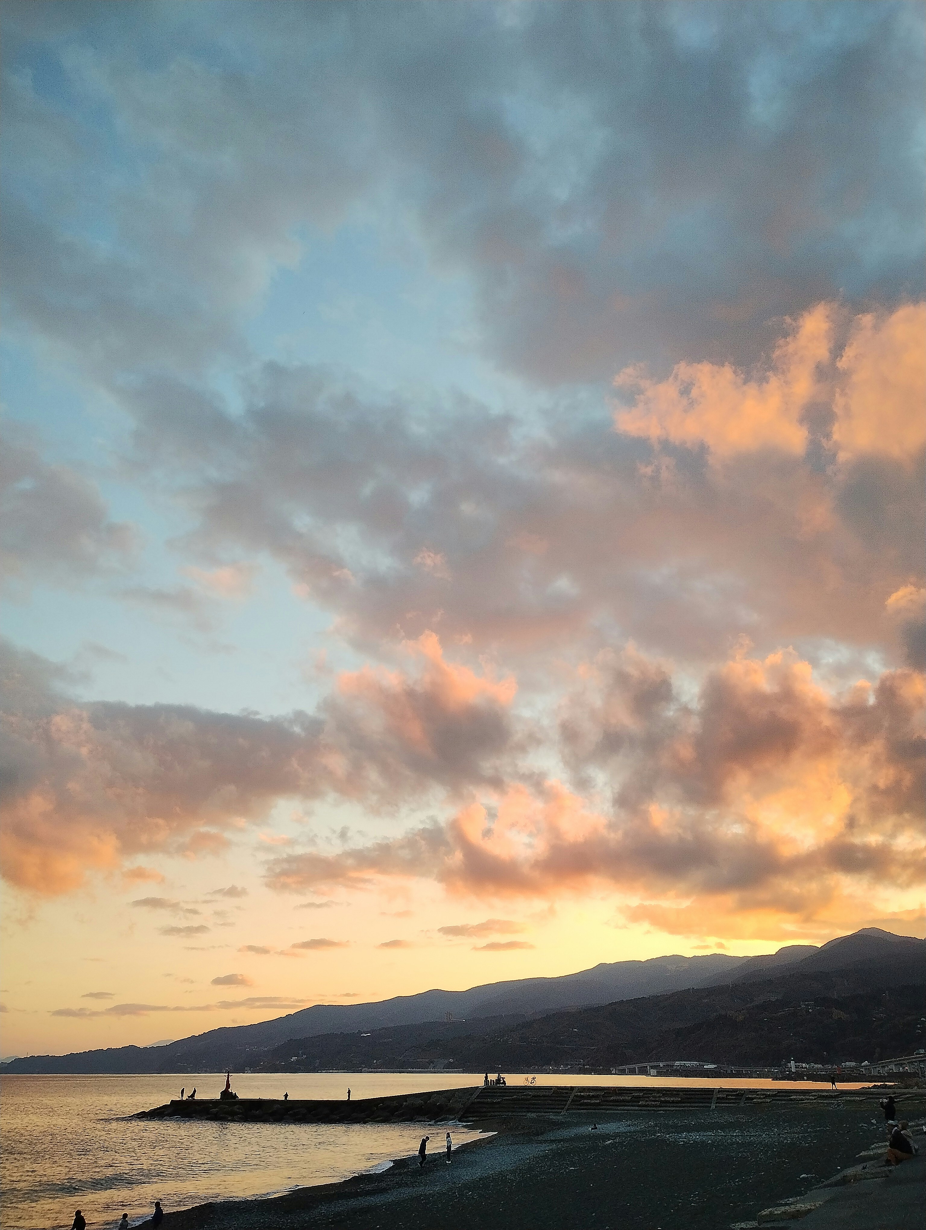夕焼けの海岸と山並みの風景