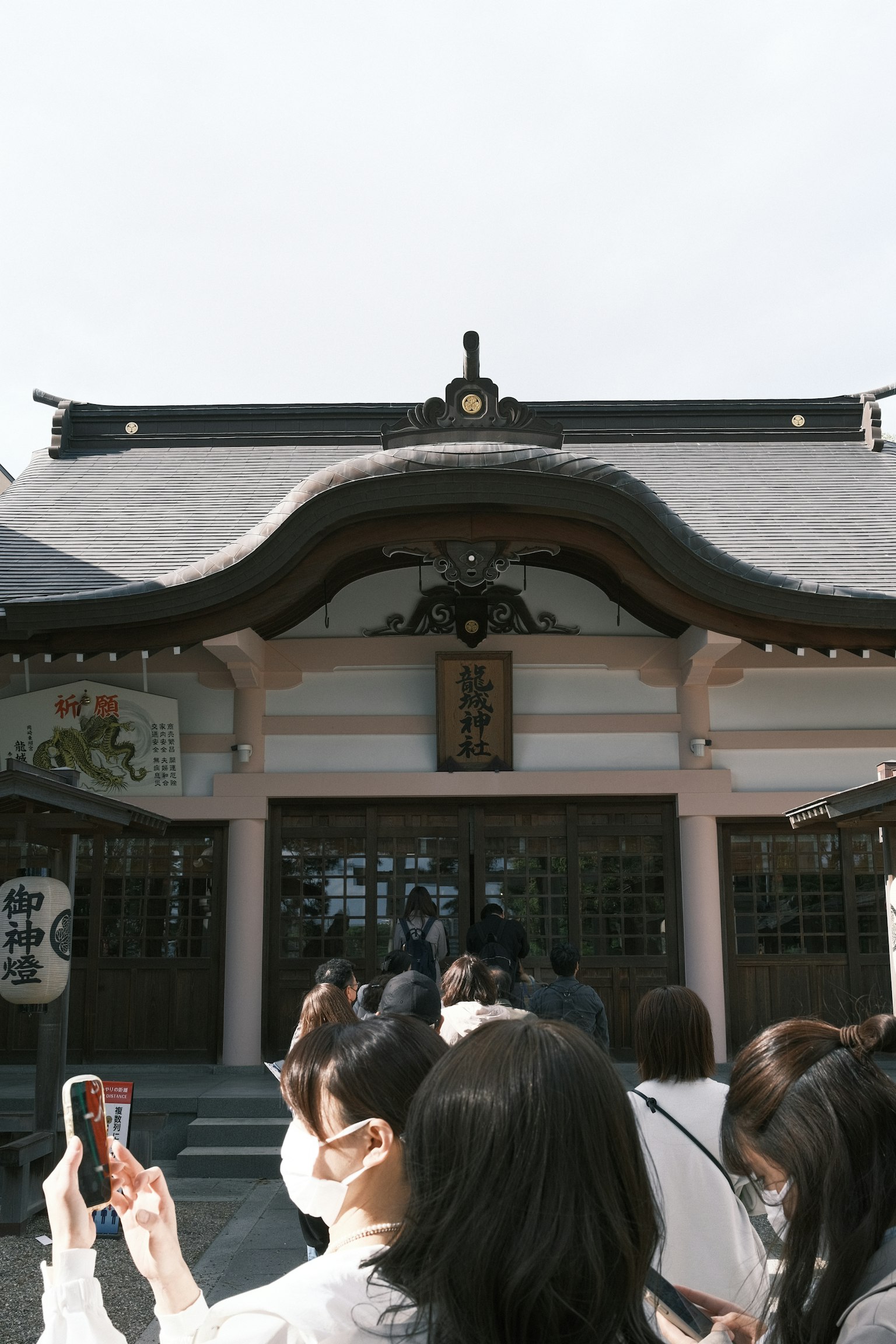 一群人在傳統日本寺廟前面，屋頂精美