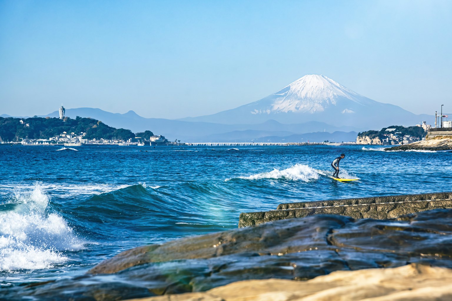 Scena di surf con oceano blu e Monte Fuji innevato