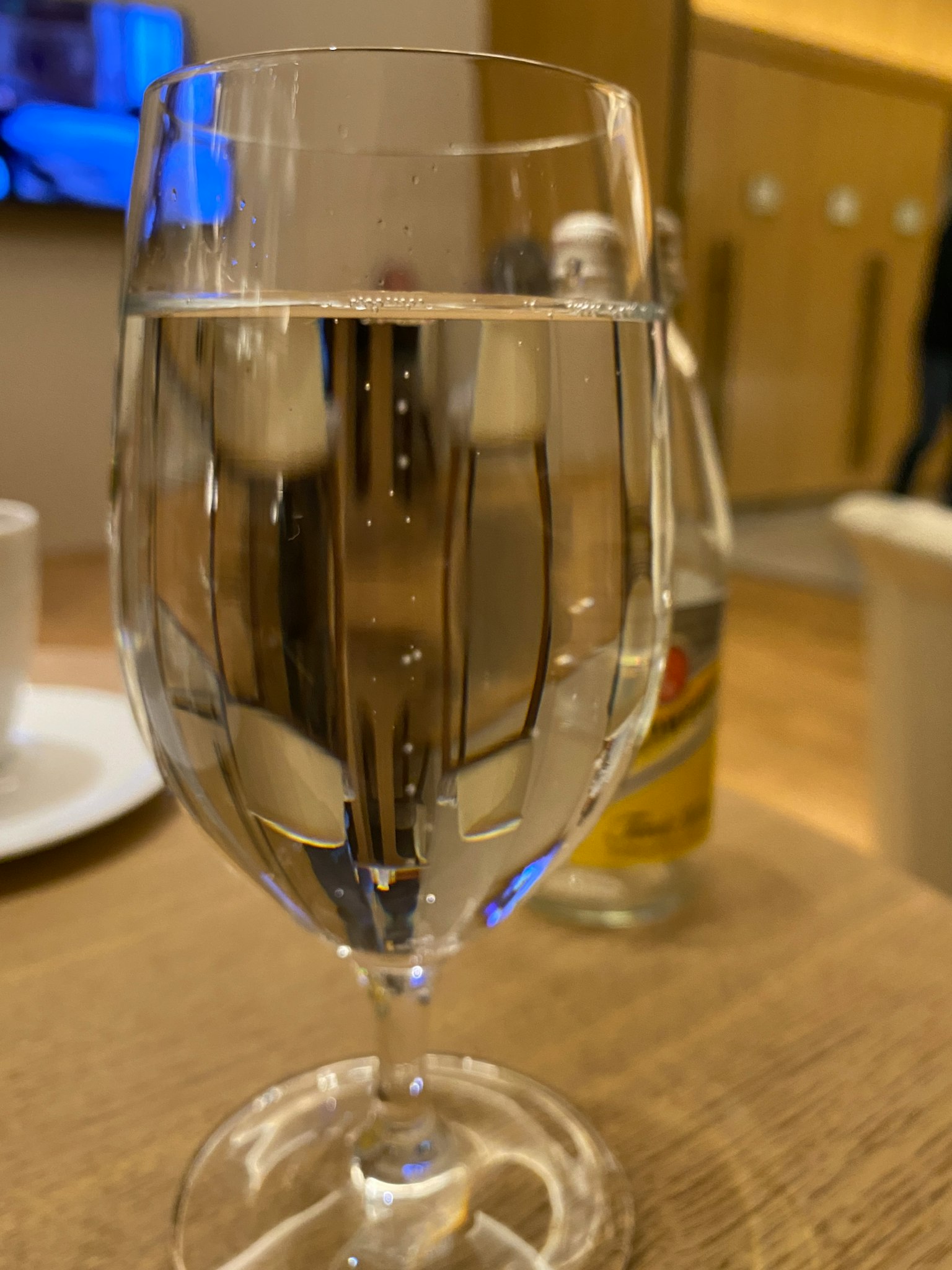 테이블 위에 있는 투명한 물이 담긴 컵과 흐릿한 인테리어 배경