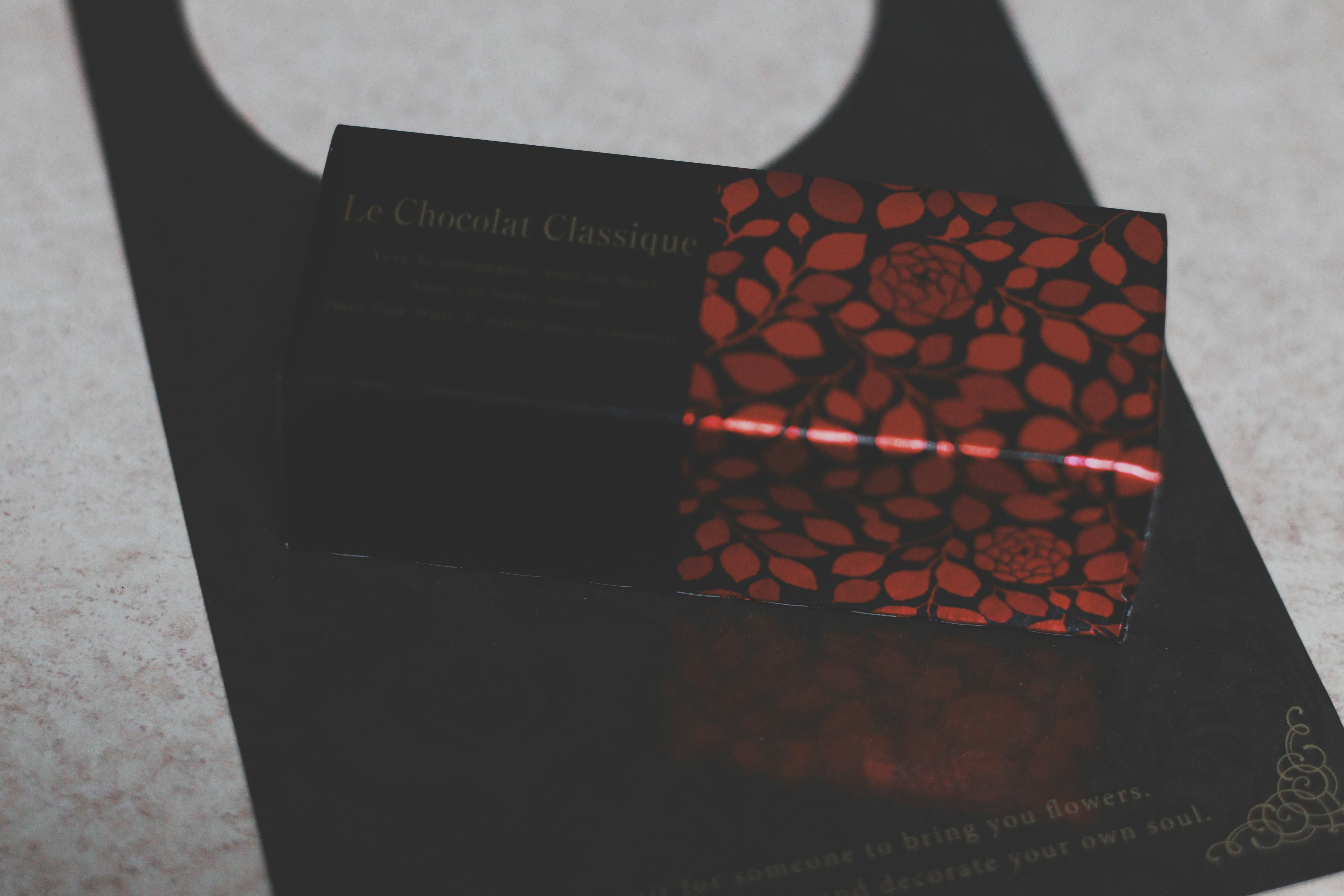 close-up amplop hitam dengan kartu bermotif merah