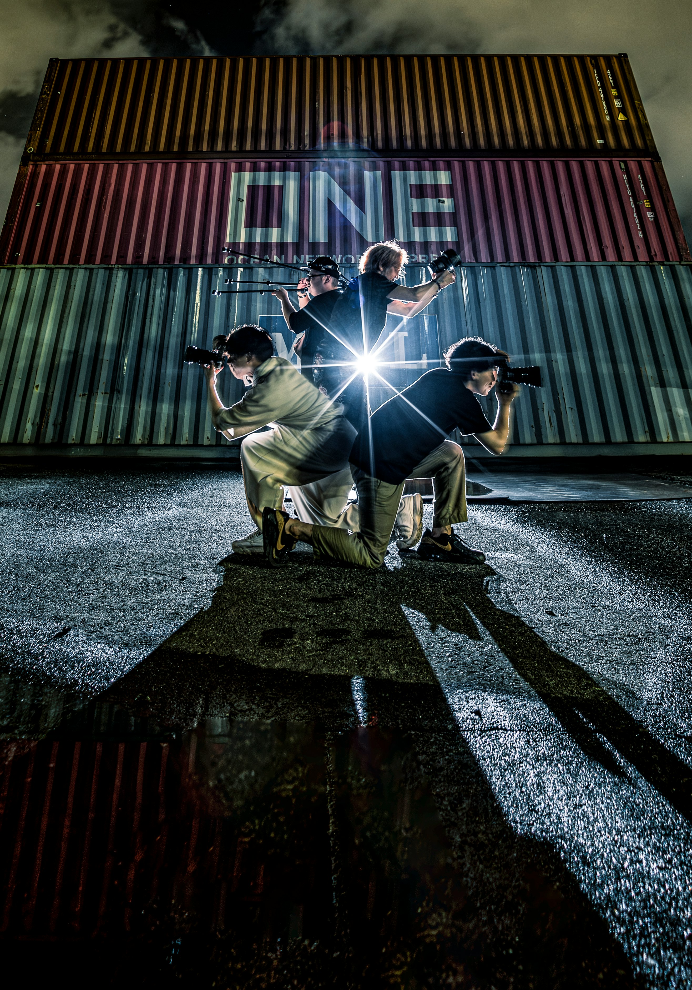 people shining lights in front of a container wall