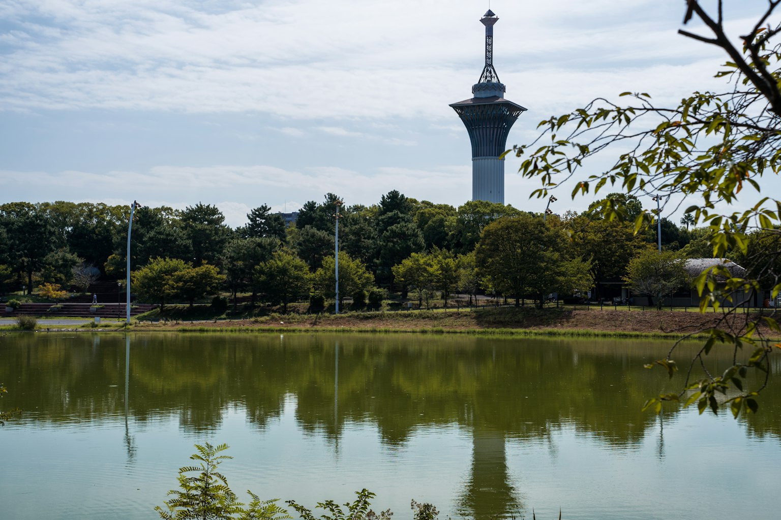 Turm neben einem See umgeben von grünen Bäumen