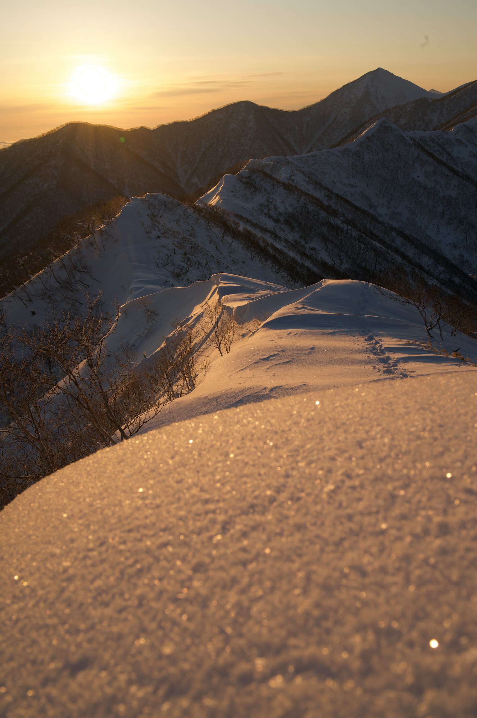 Sonnenuntergang von einem schneebedeckten Berggipfel