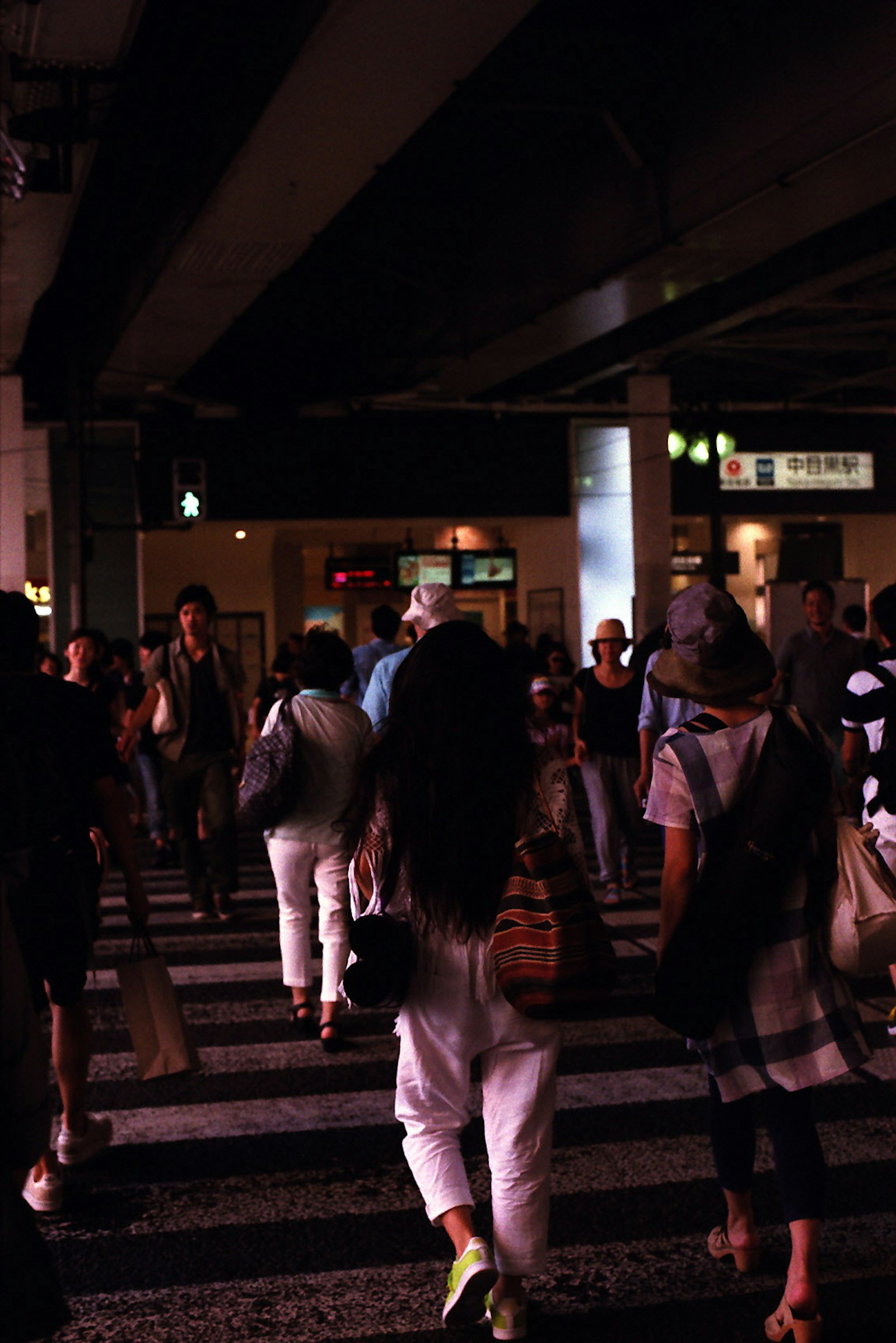 Personas cruzando una calle en una ciudad de noche