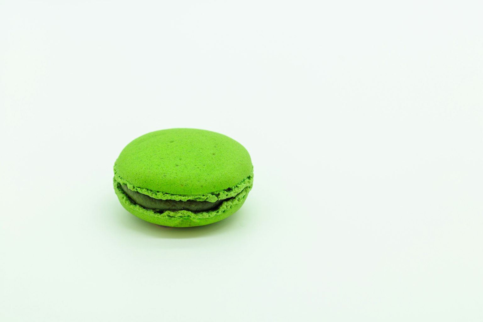A green macaron on a white background