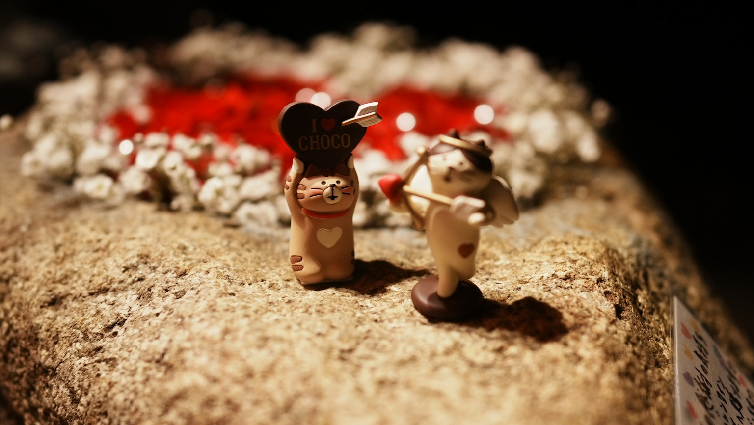 Piccole figure in ceramica che tengono un cuore e un'altra che suona uno strumento
