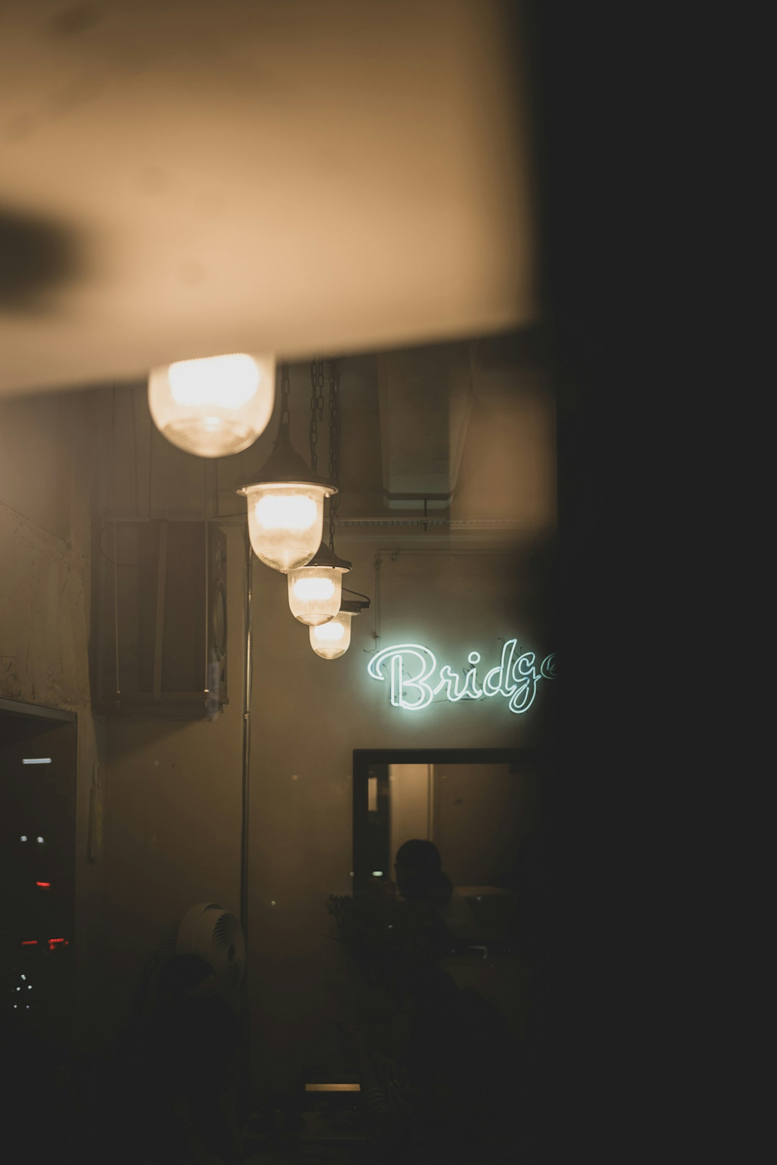 室内视图，带有明亮的灯和蓝色霓虹灯标志，写着'Bridgy'
